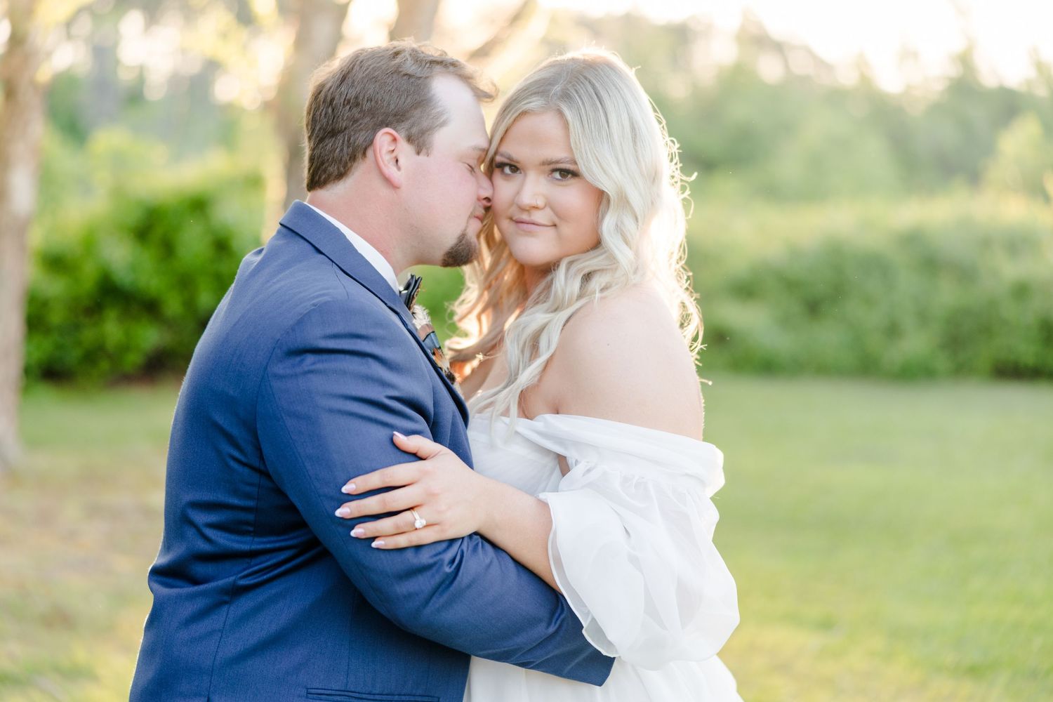 A joyful wedding embrace captured outdoors in natural lighting.