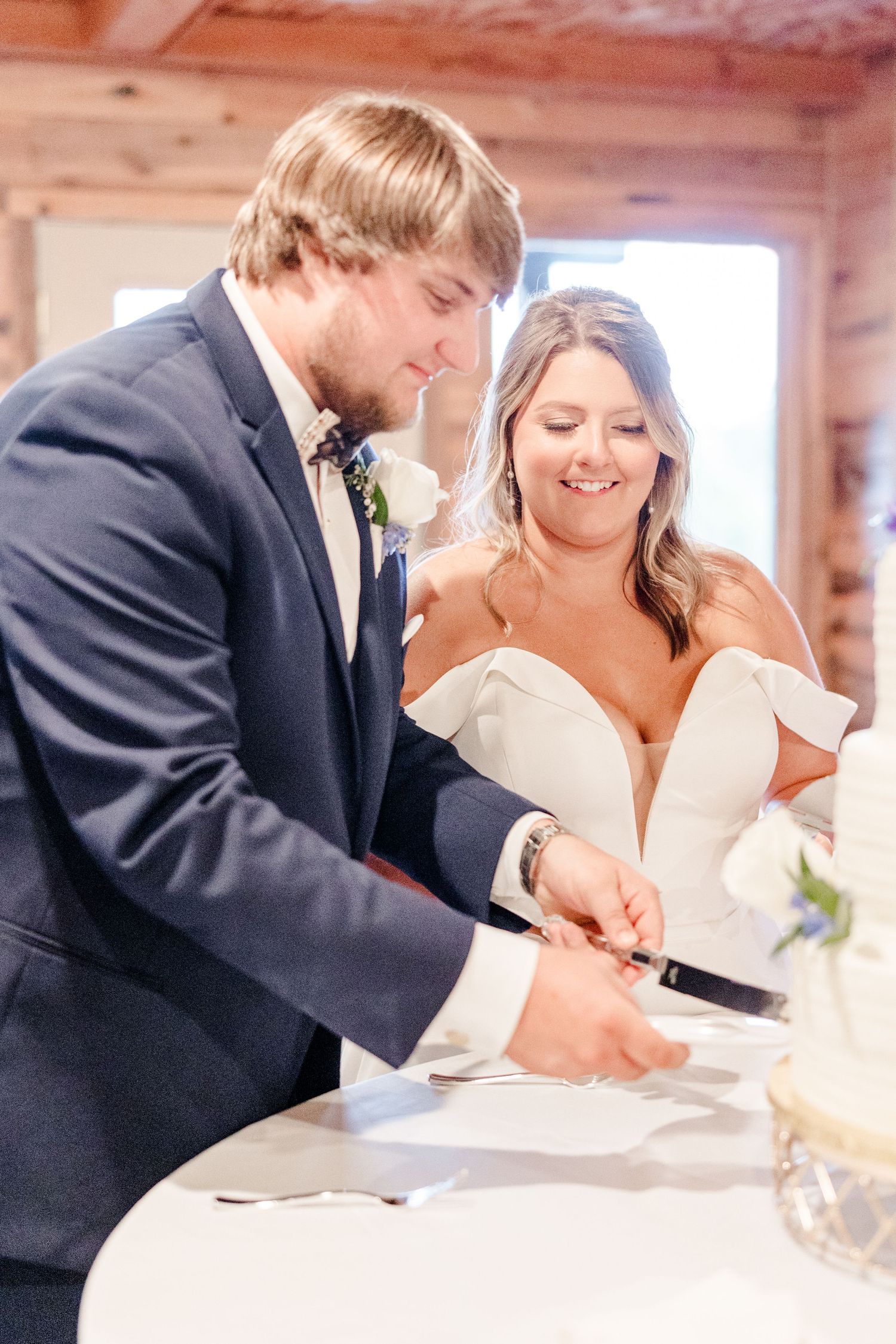 A couple signs their marriage license in a rustic wooden cabin setting.