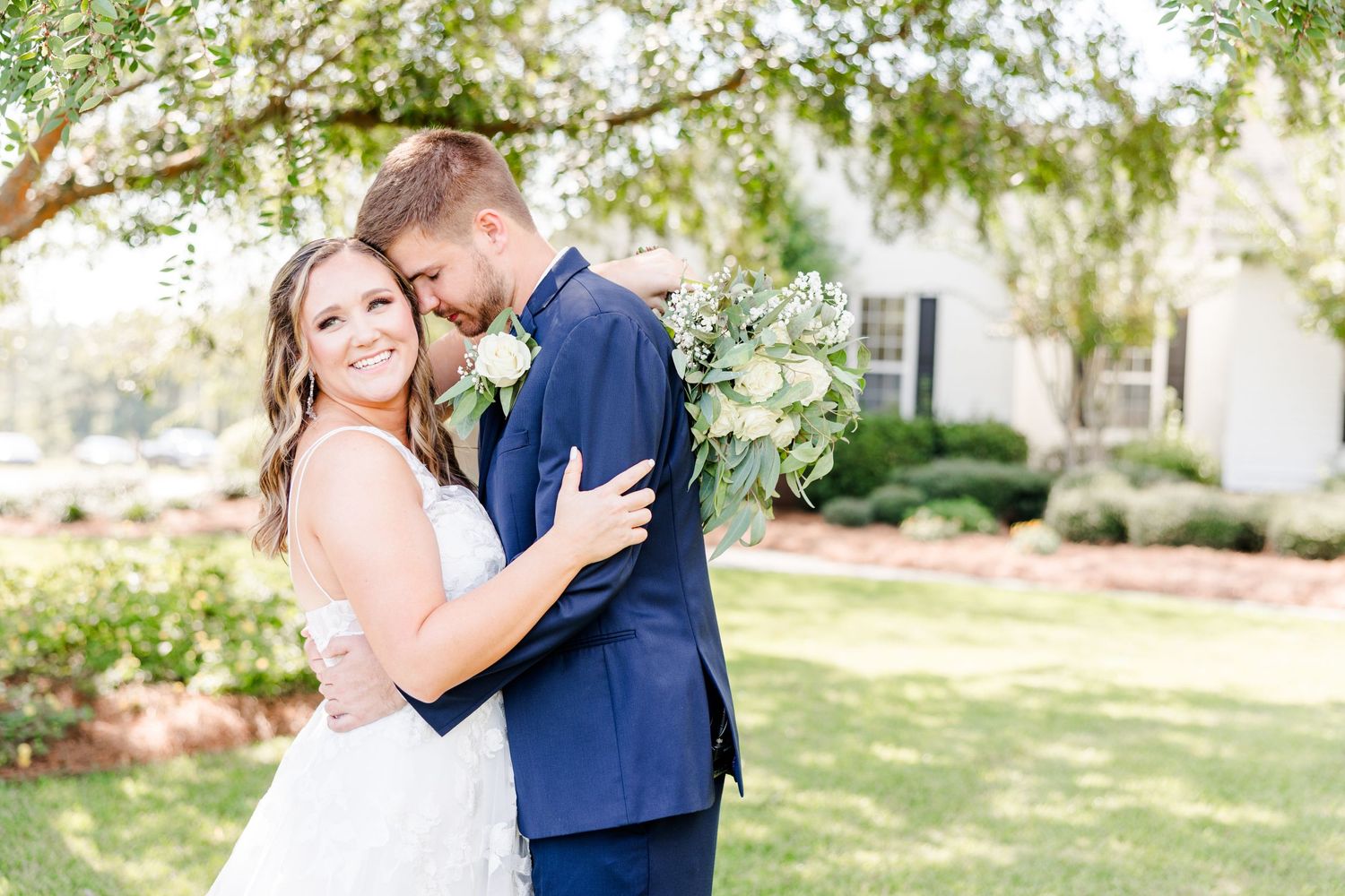 Natural light wedding photography featuring couple in traditional attire among garden trees.