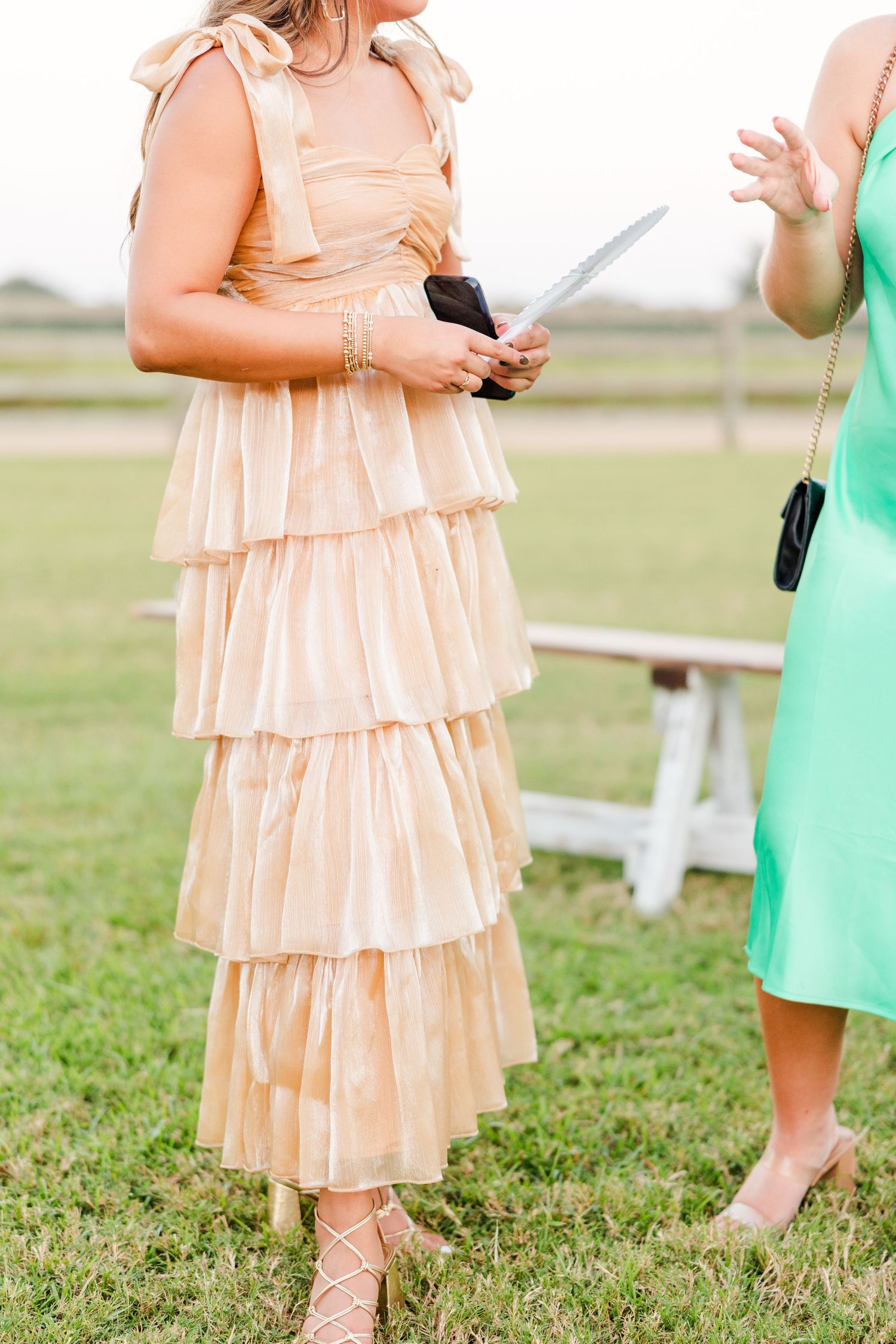 Peach-colored tiered ruffle dresses worn at an outdoor celebration.