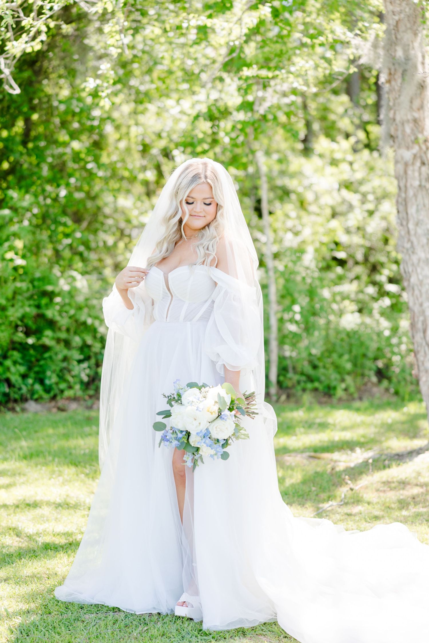 Elegant bridal portraits in a sunlit garden setting with white flowers and flowing veil.