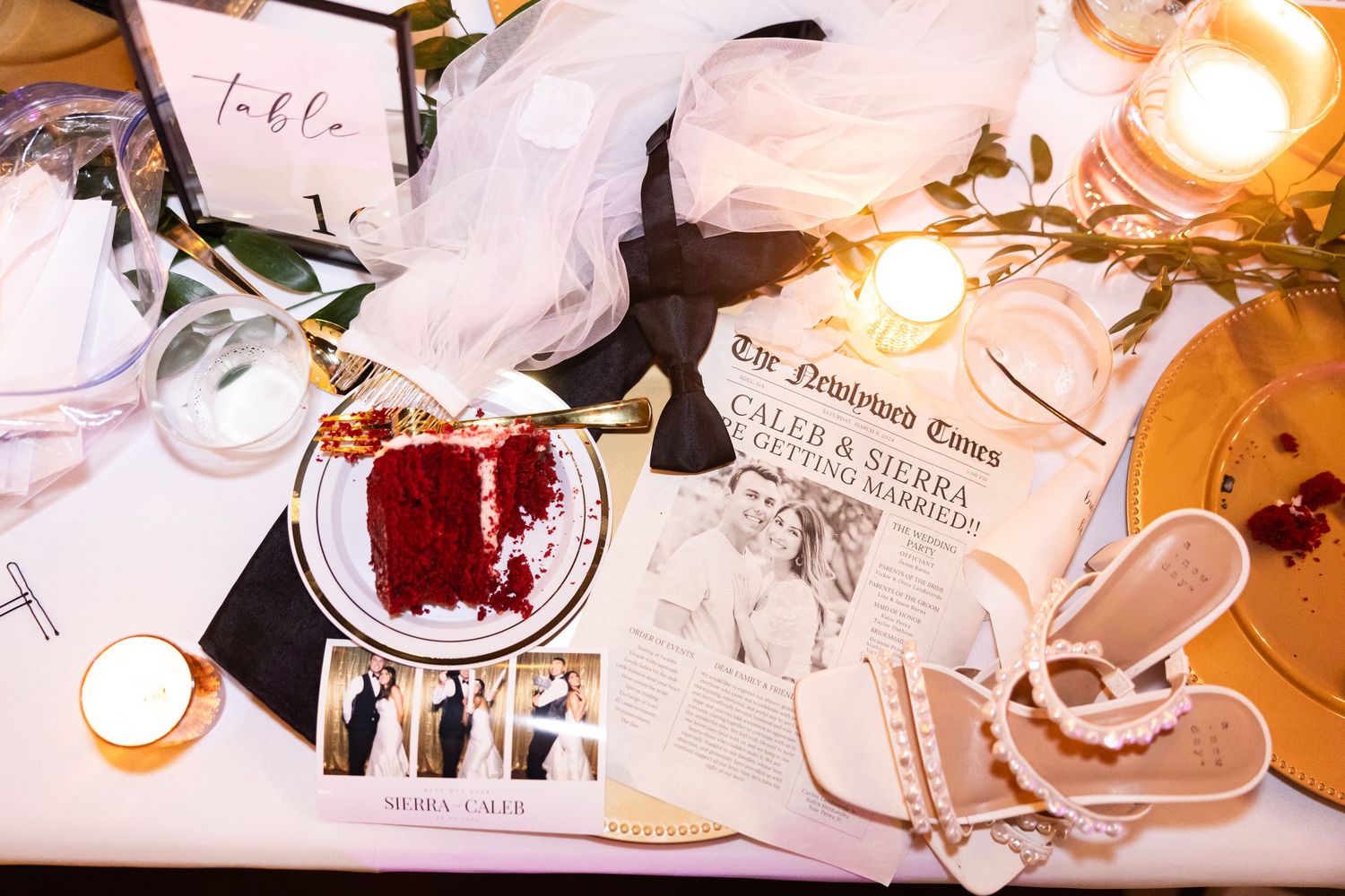 Wedding details including red wine, invitation, and bridal accessories on table.
