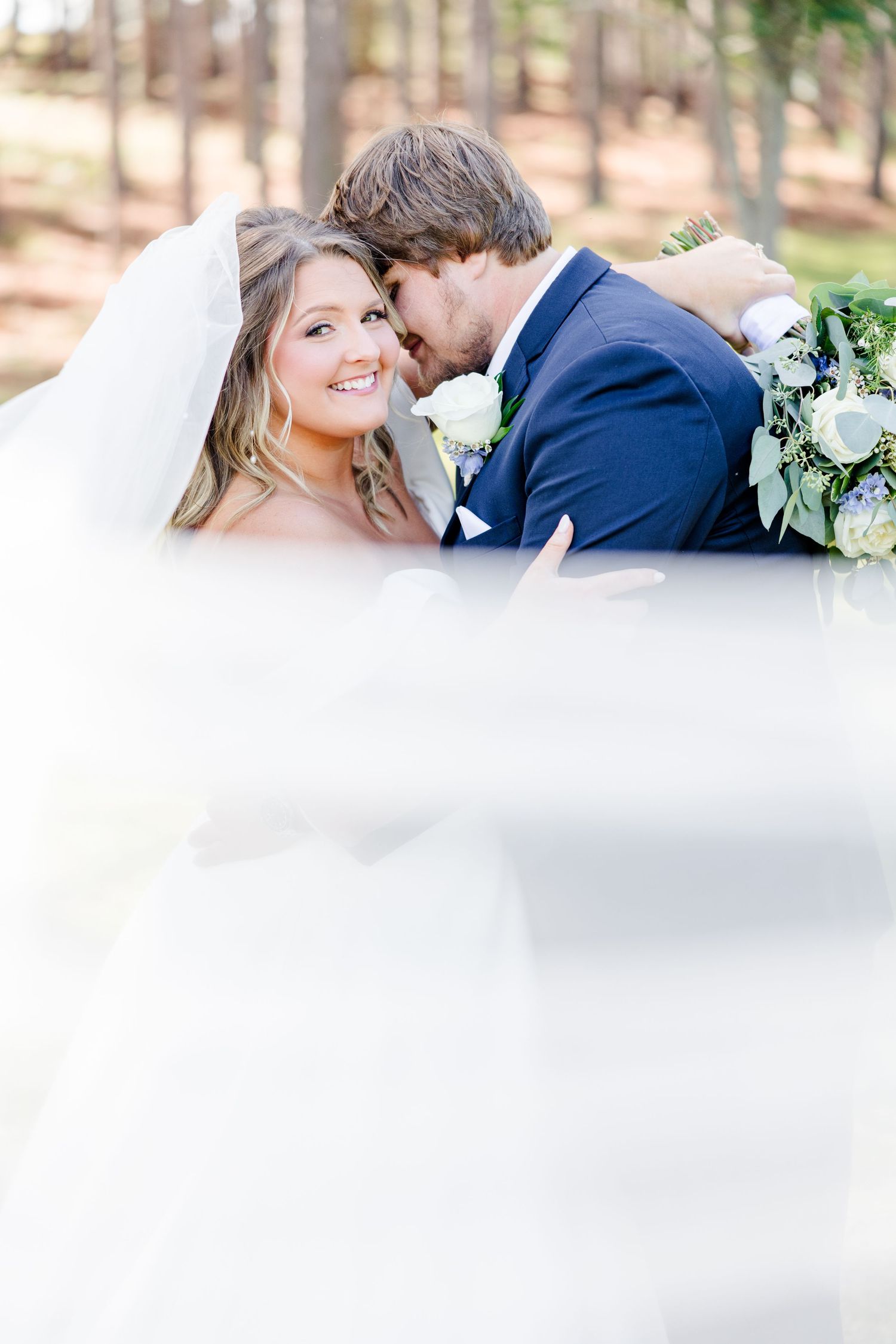 Joyful wedding moment captured between bride and groom with soft natural lighting.