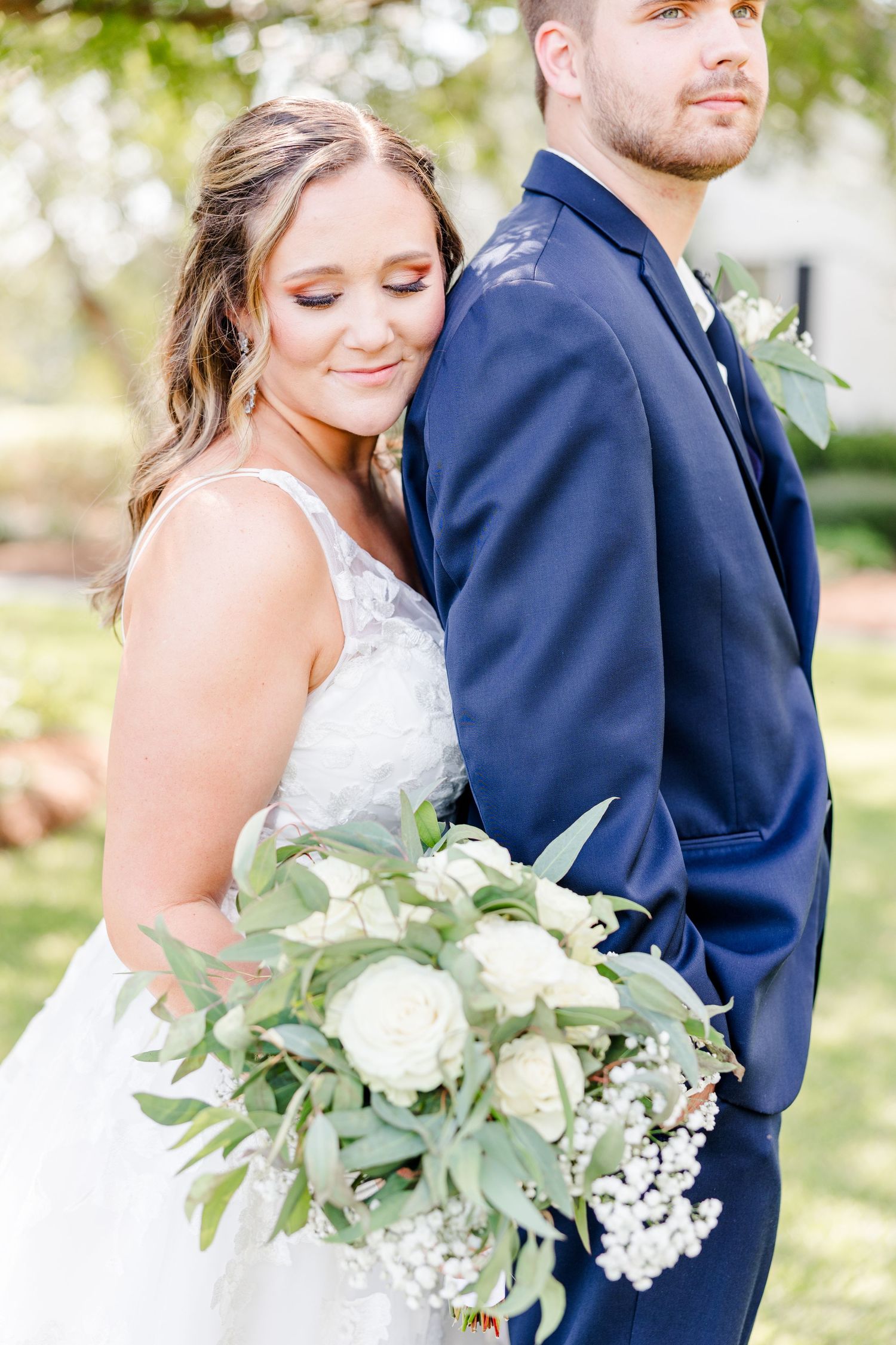 Romantic wedding portraits with white floral bouquet and elegant navy and white attire.