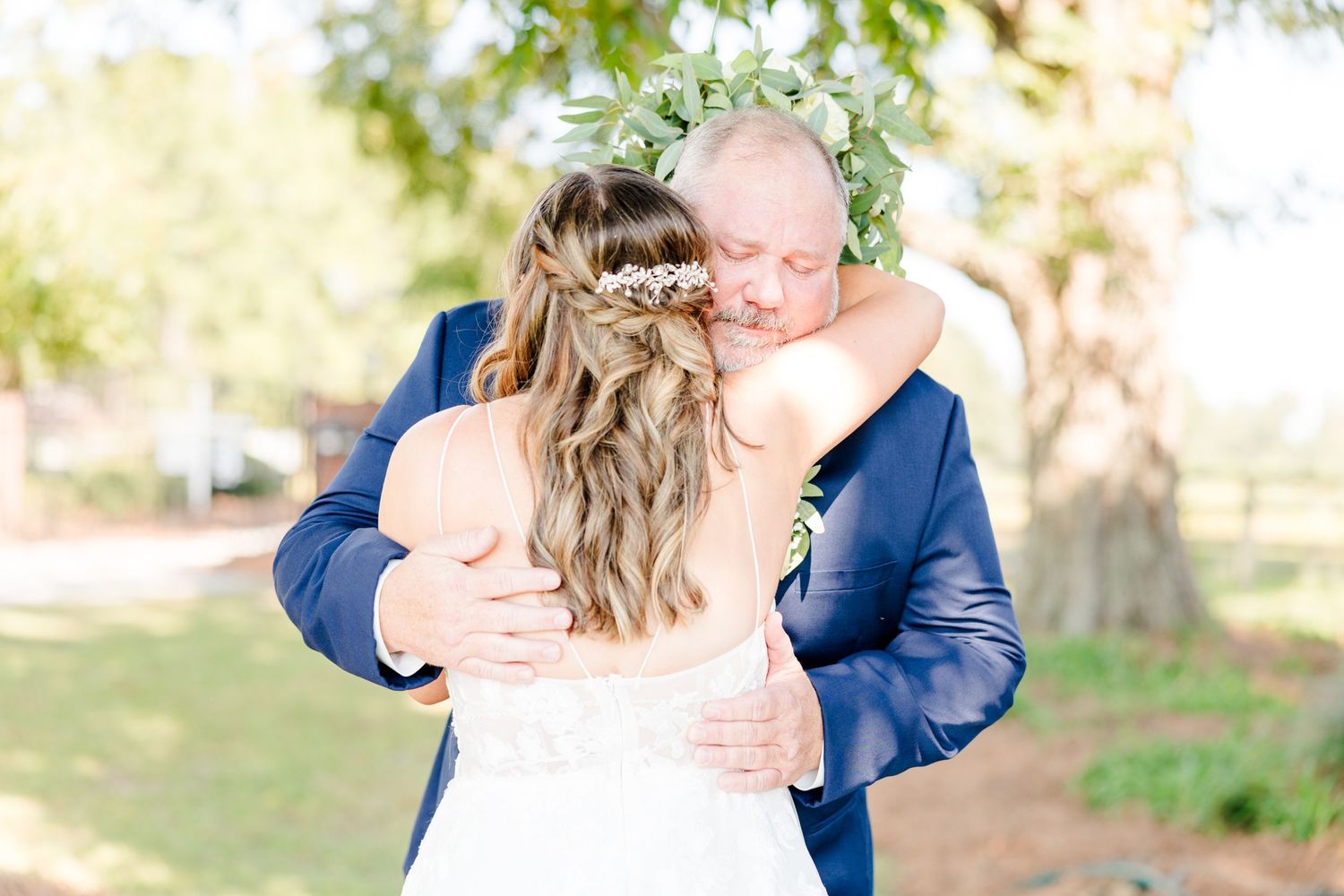 Candid first look wedding moments captured in a natural outdoor setting with greenery.