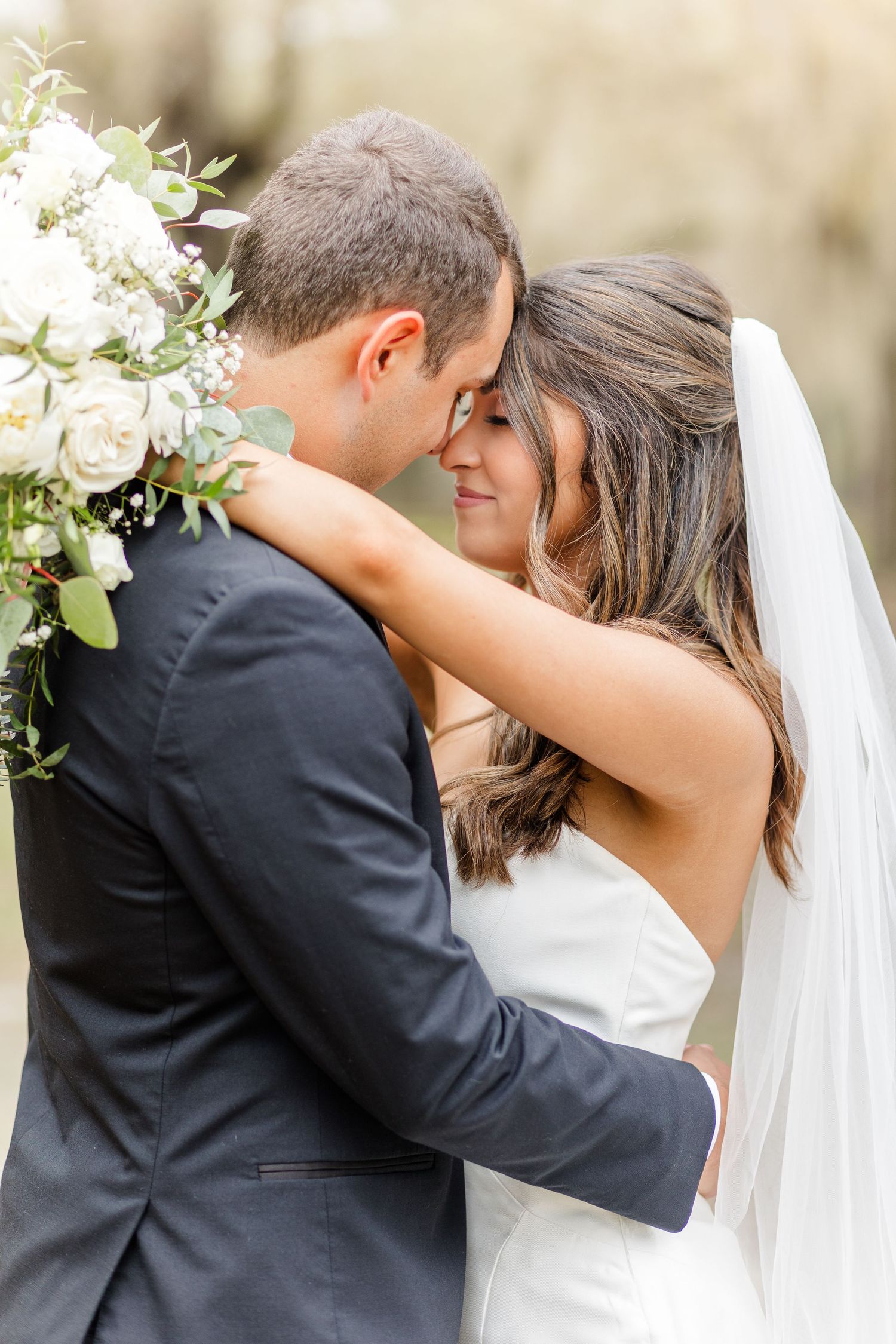 A tender embrace between newlyweds during their outdoor wedding photoshoot.