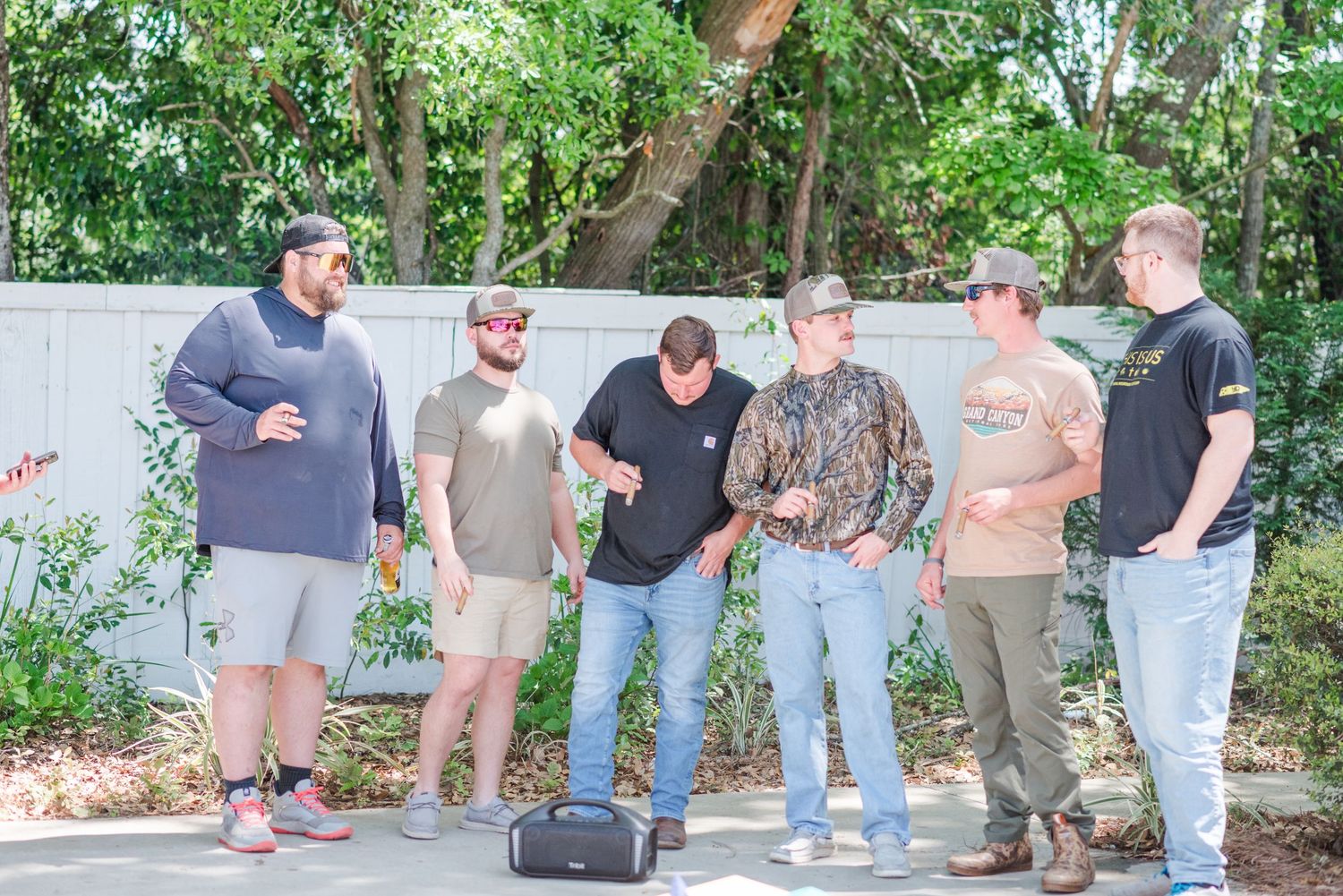 Casual wedding guests gather outdoors in relaxed attire.