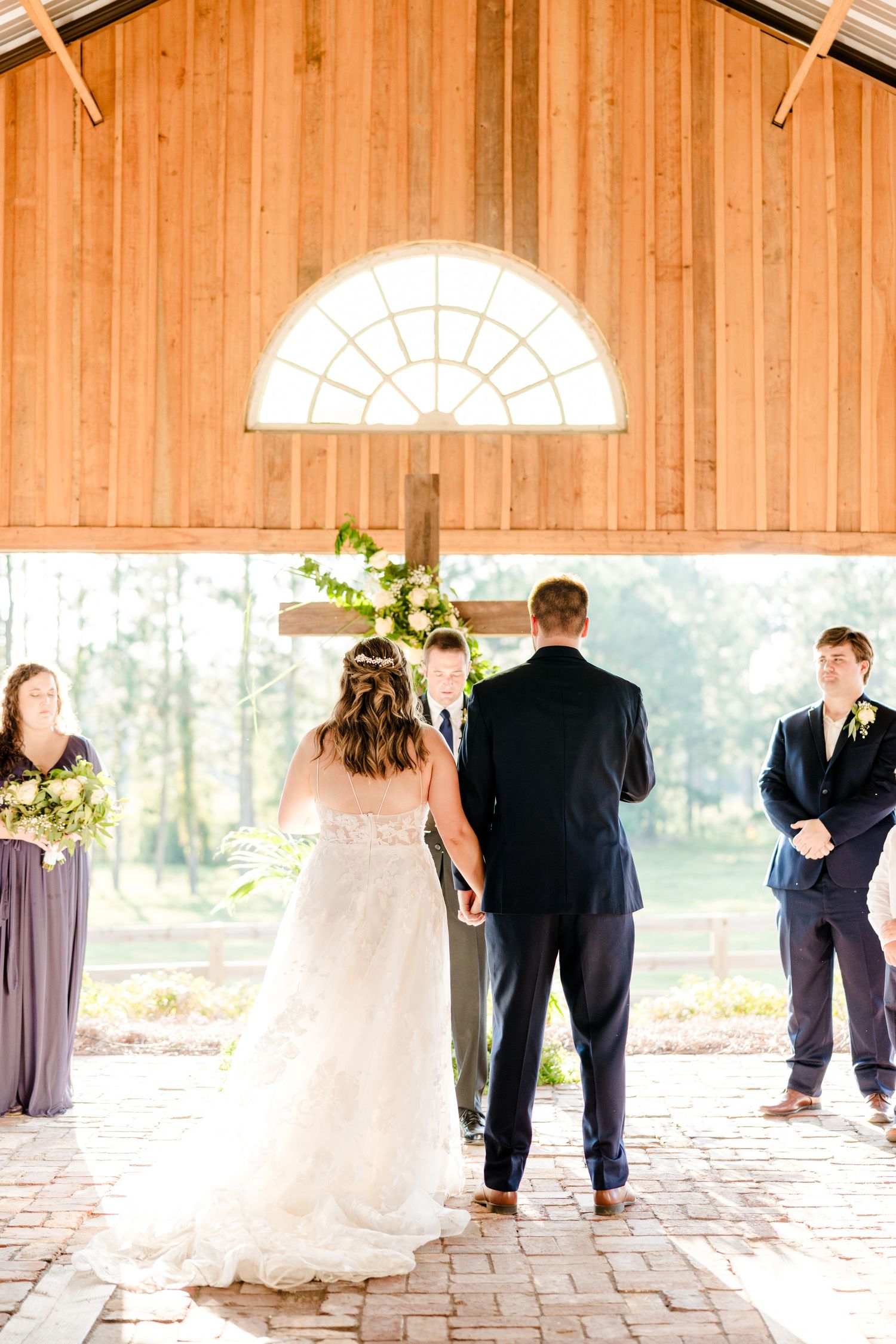 Wedding ceremony moments captured in a rustic barn with natural lighting.