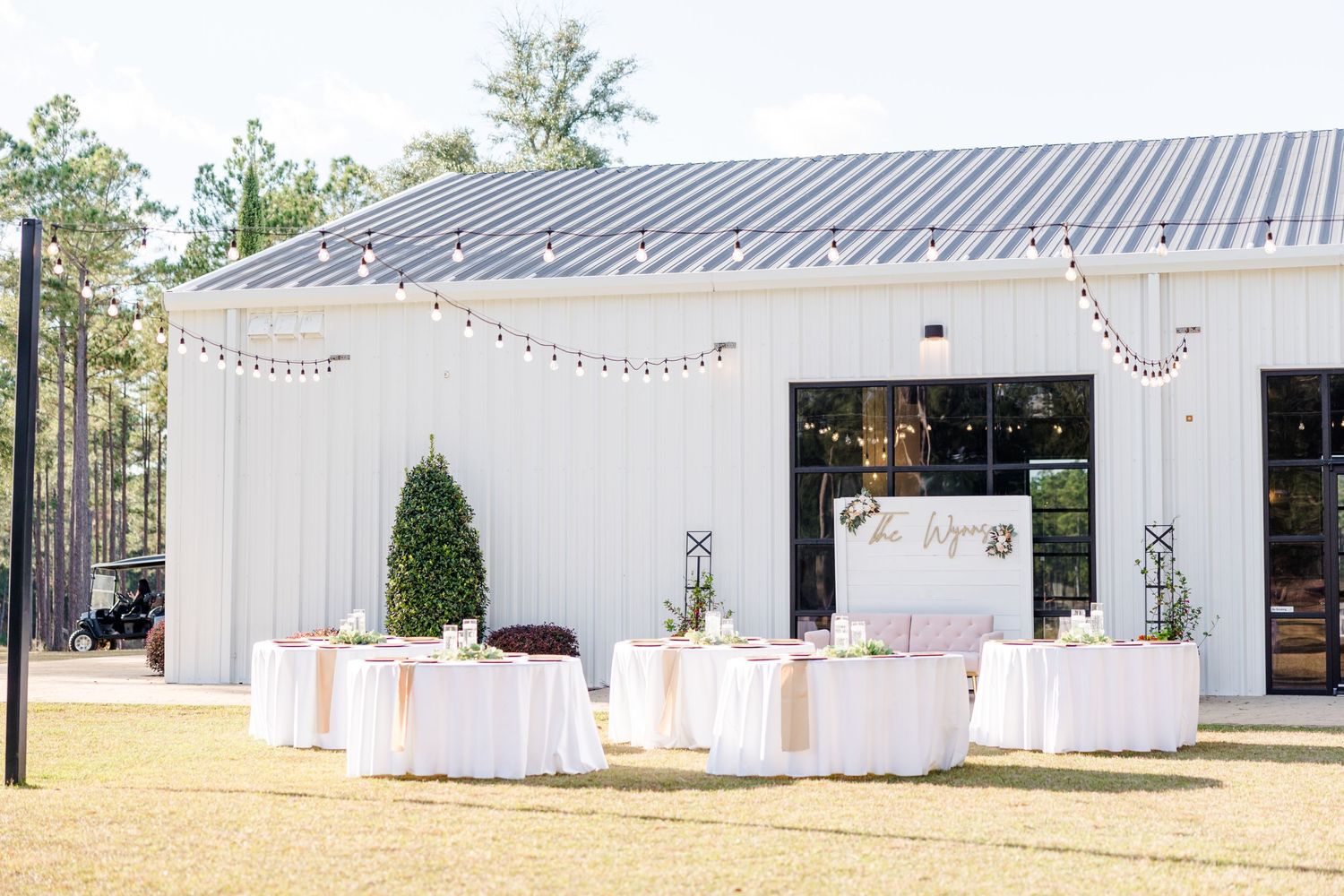 White modern wedding venue exterior with elegant landscaping and minimalist design.