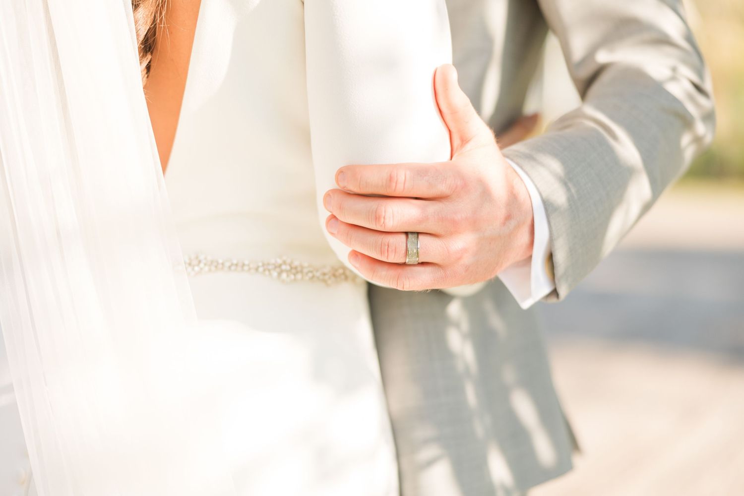 Close-up details of wedding attire in soft natural lighting.