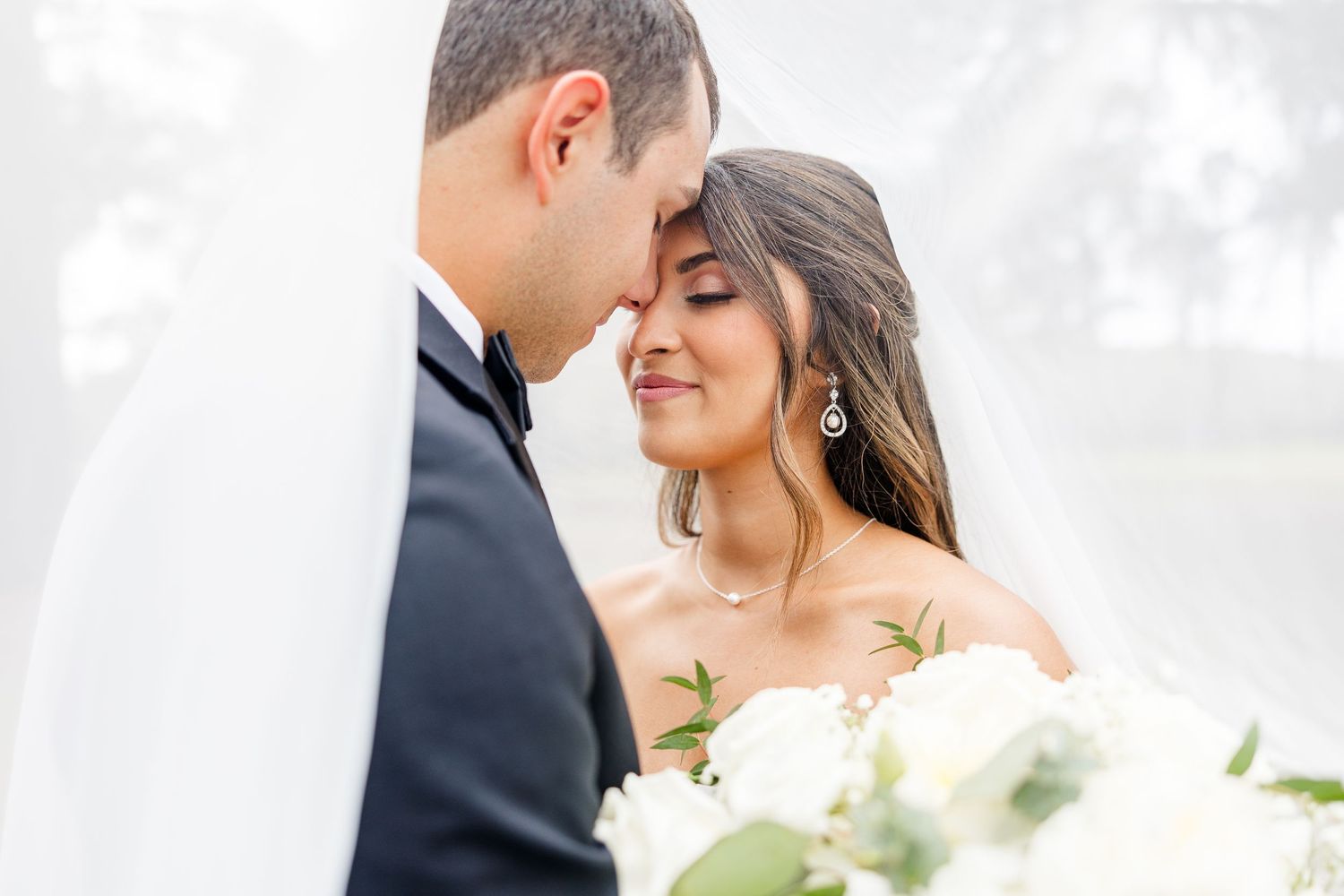 A tender wedding portrait showing a close-up intimate moment between newlyweds.