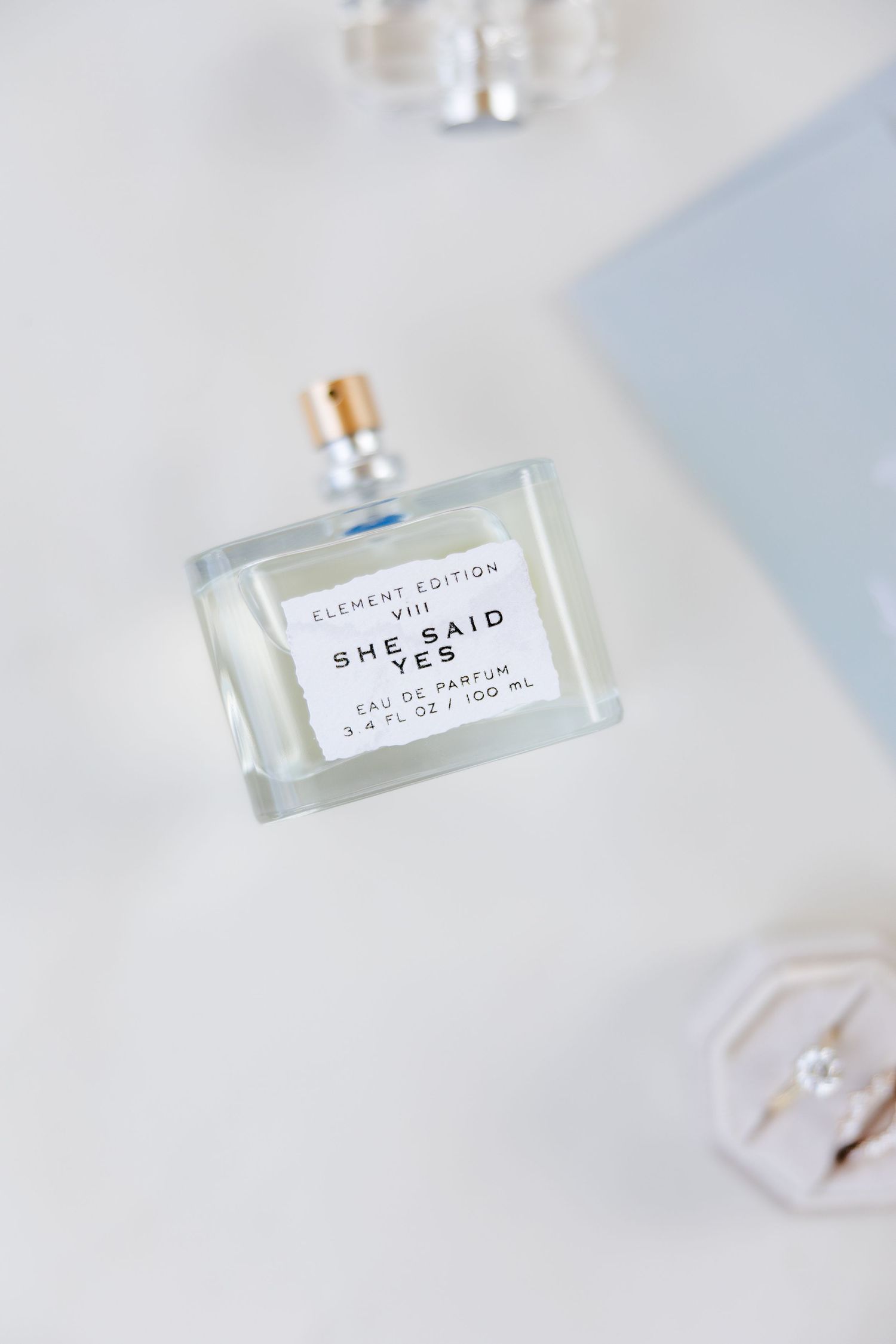 Wedding perfume bottle labeled 'She Said' on white surface.
