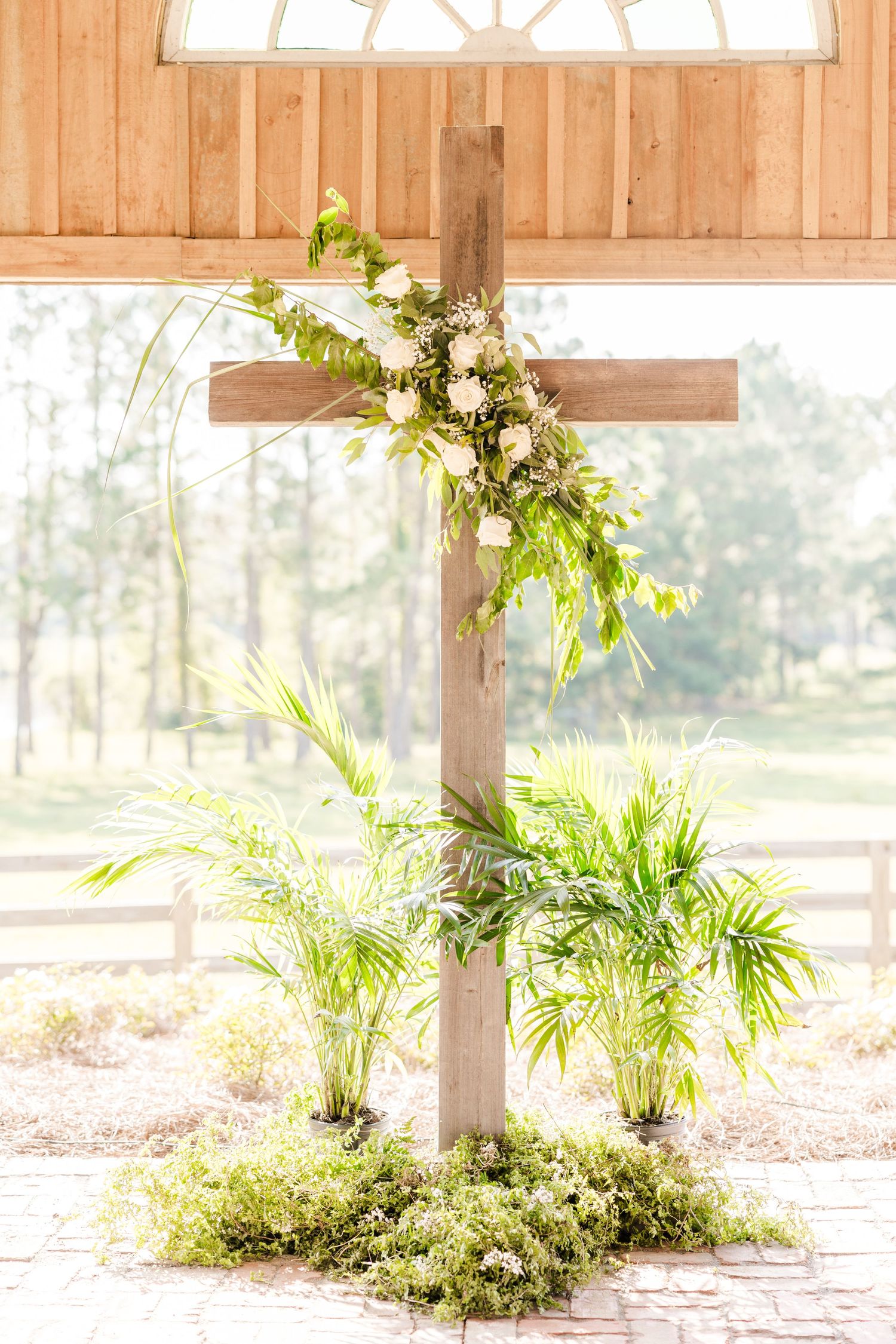 Sunlit wooden pavilion decorated with tropical plants and greenery.