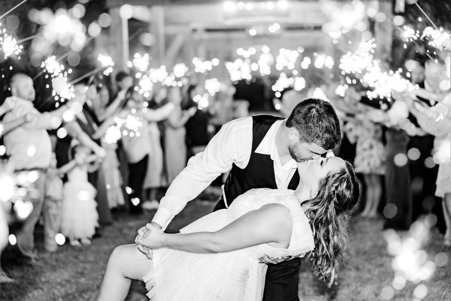 Black and white photo capturing joyful moments during a wedding reception dance party.