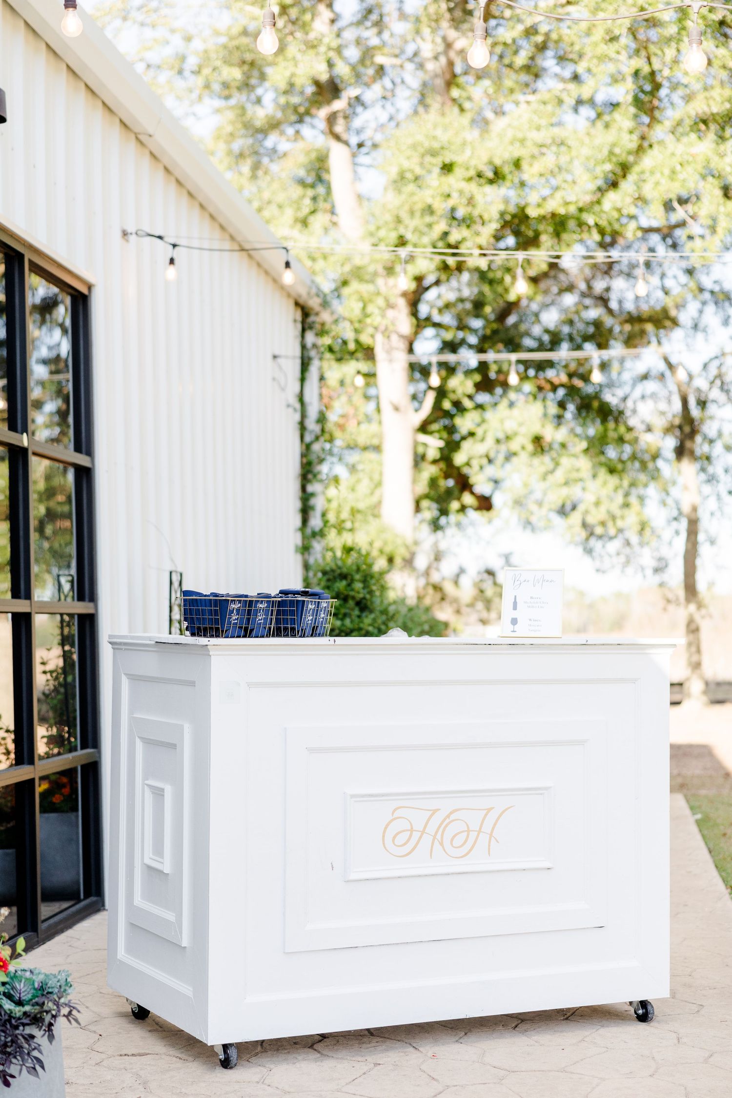 Modern white modular bar setup with black-framed windows and outdoor greenery.