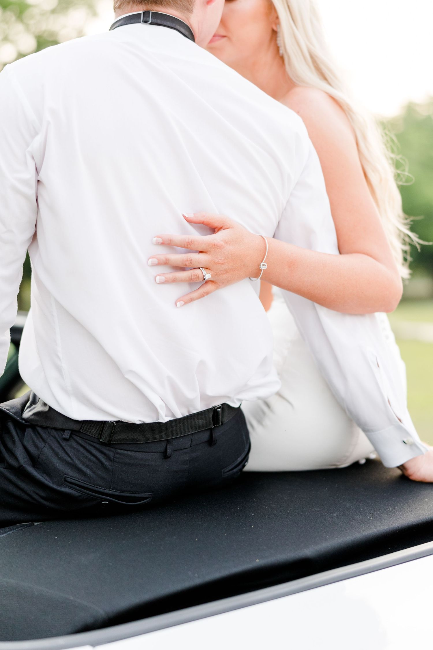 Intimate black and white wedding portrait showing couple sitting close together.