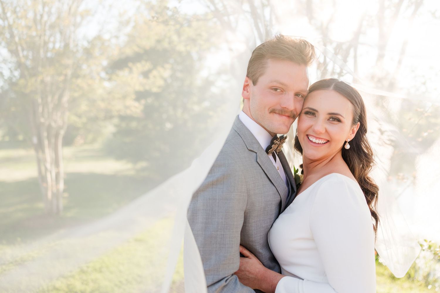 Sunlit wedding portraits captured in natural outdoor setting.