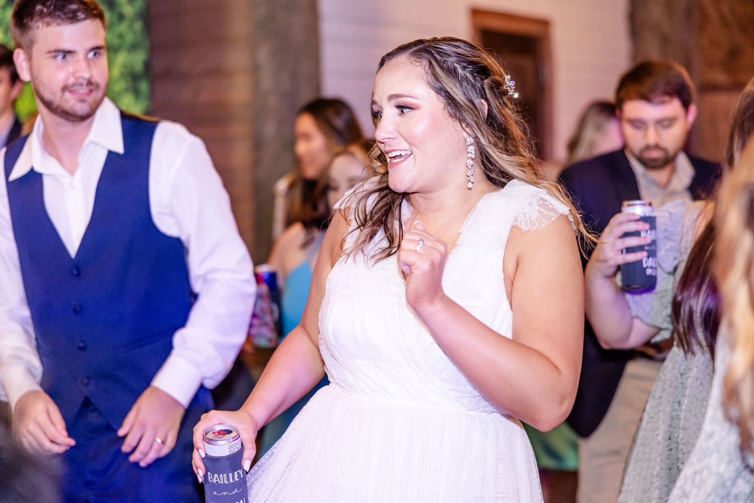 Wedding celebration with dancing and laughter at indoor venue.