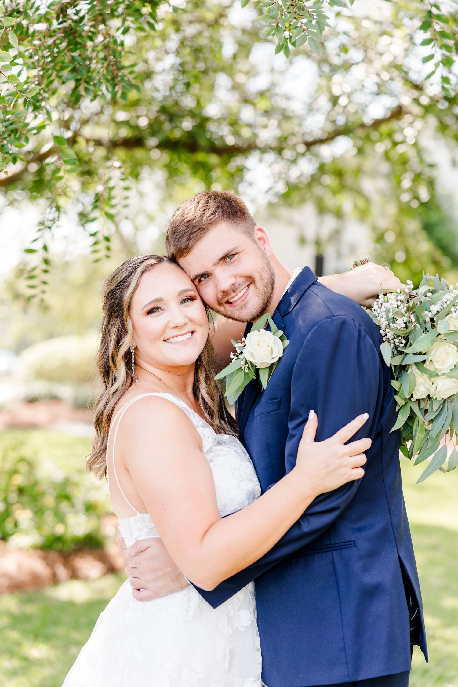 Joyful wedding couple shares candid moments in outdoor garden setting with spring greenery.