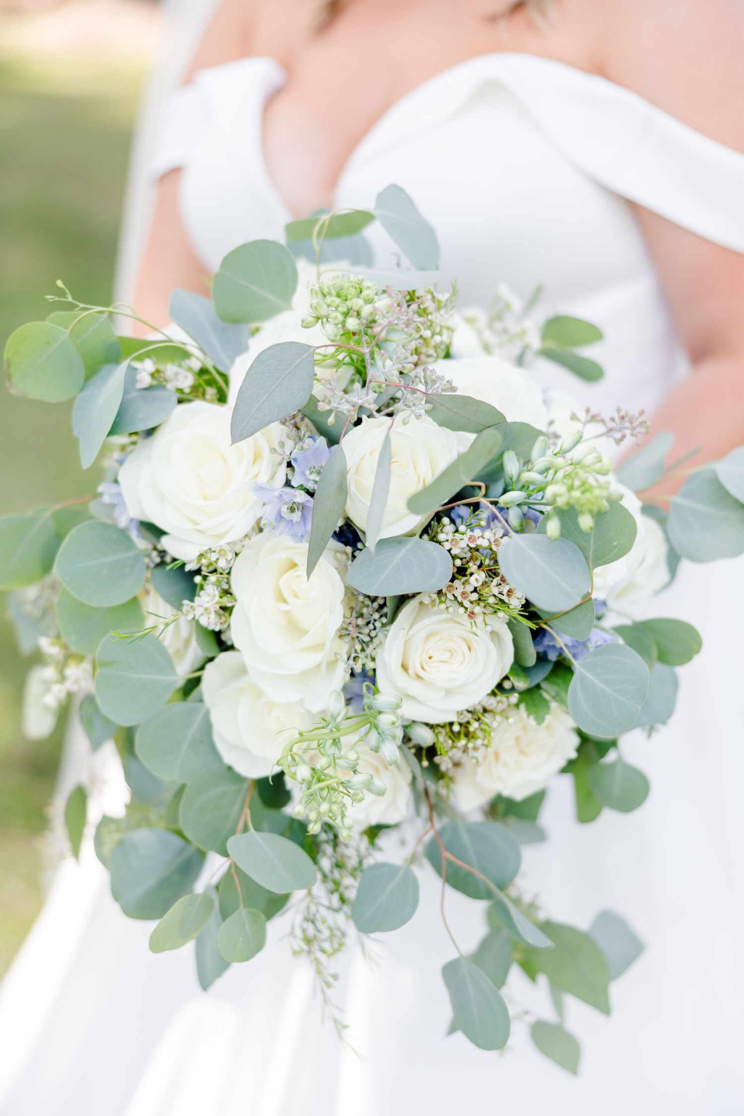 Beautiful white and green bridal bouquet with roses, eucalyptus, and delicate baby's breath.