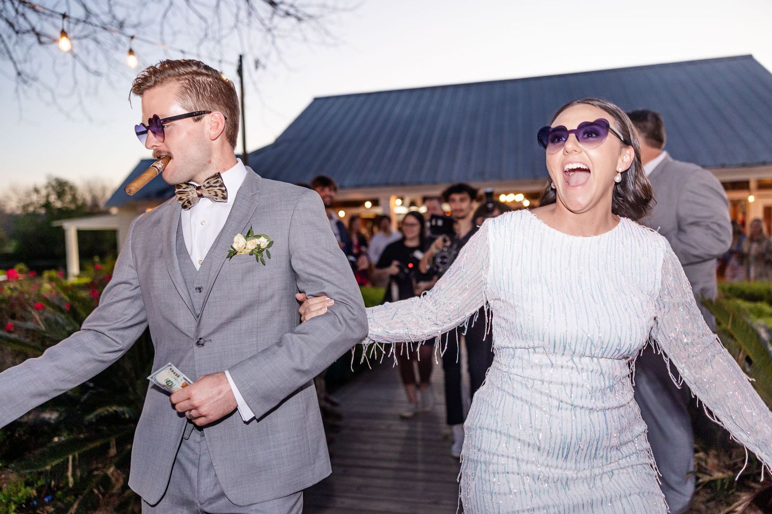Couple sharing a joyful moment outdoors with a barn-style building in the background.