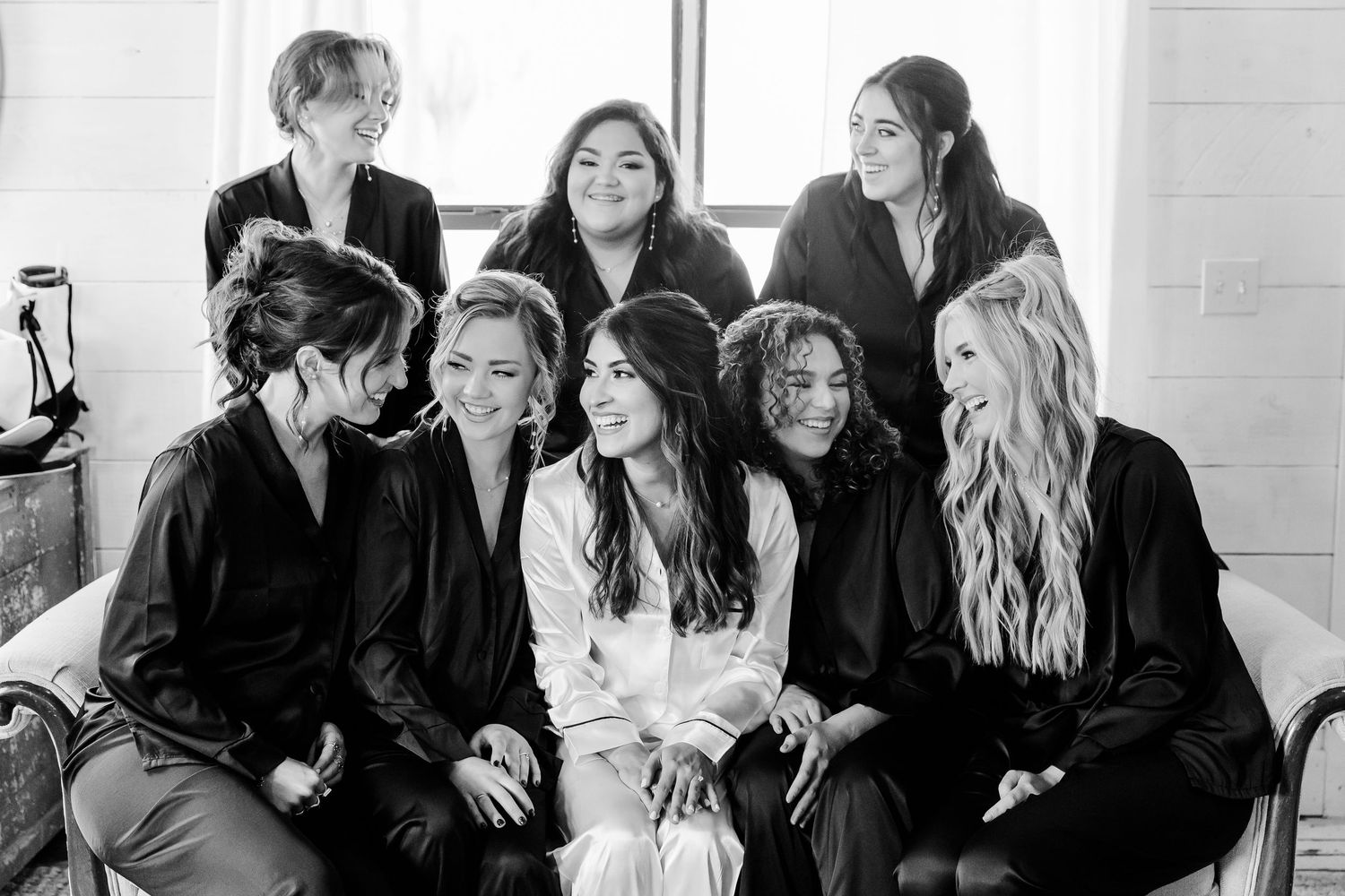 Wedding party gathered together for casual black and white portrait.