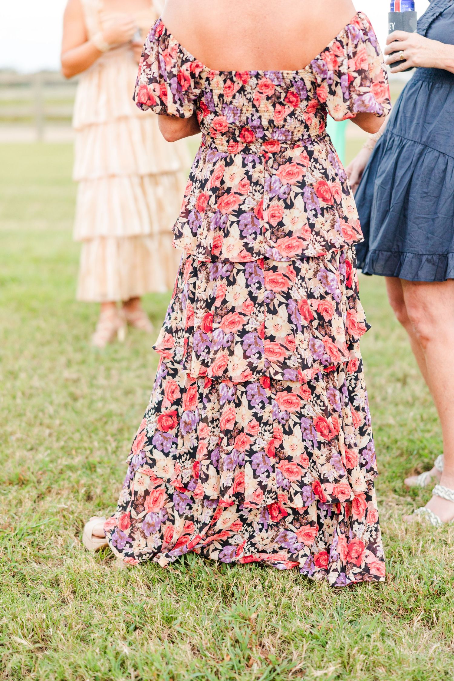 Floral print dresses in pink and navy seen at an outdoor wedding.