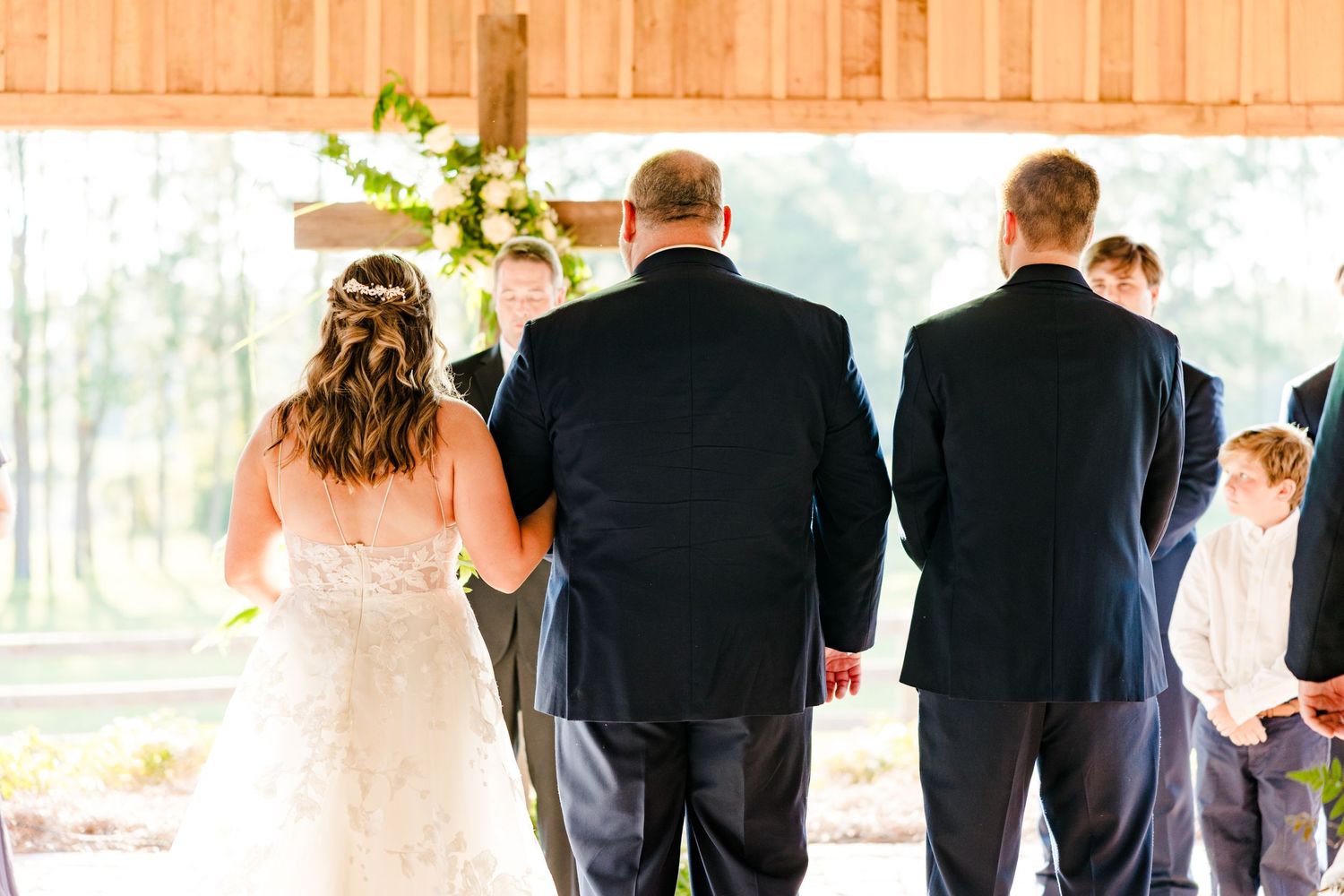 Wedding party members lined up in formal attire at an outdoor venue.
