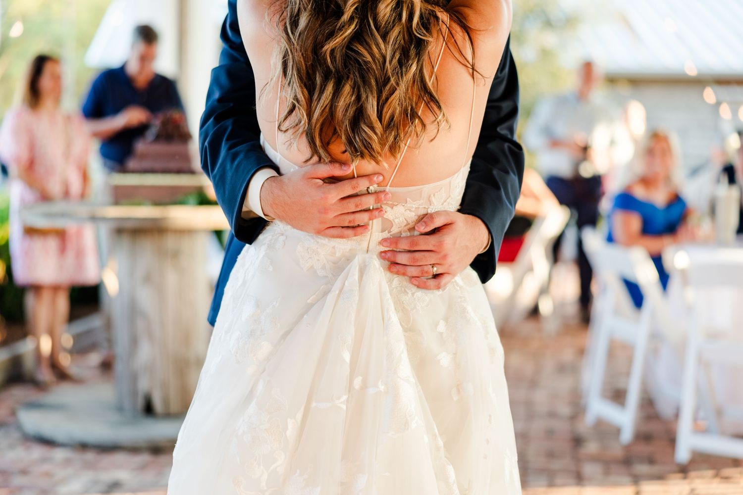 Wedding couple shares an intimate cake feeding moment at their rustic barn reception.