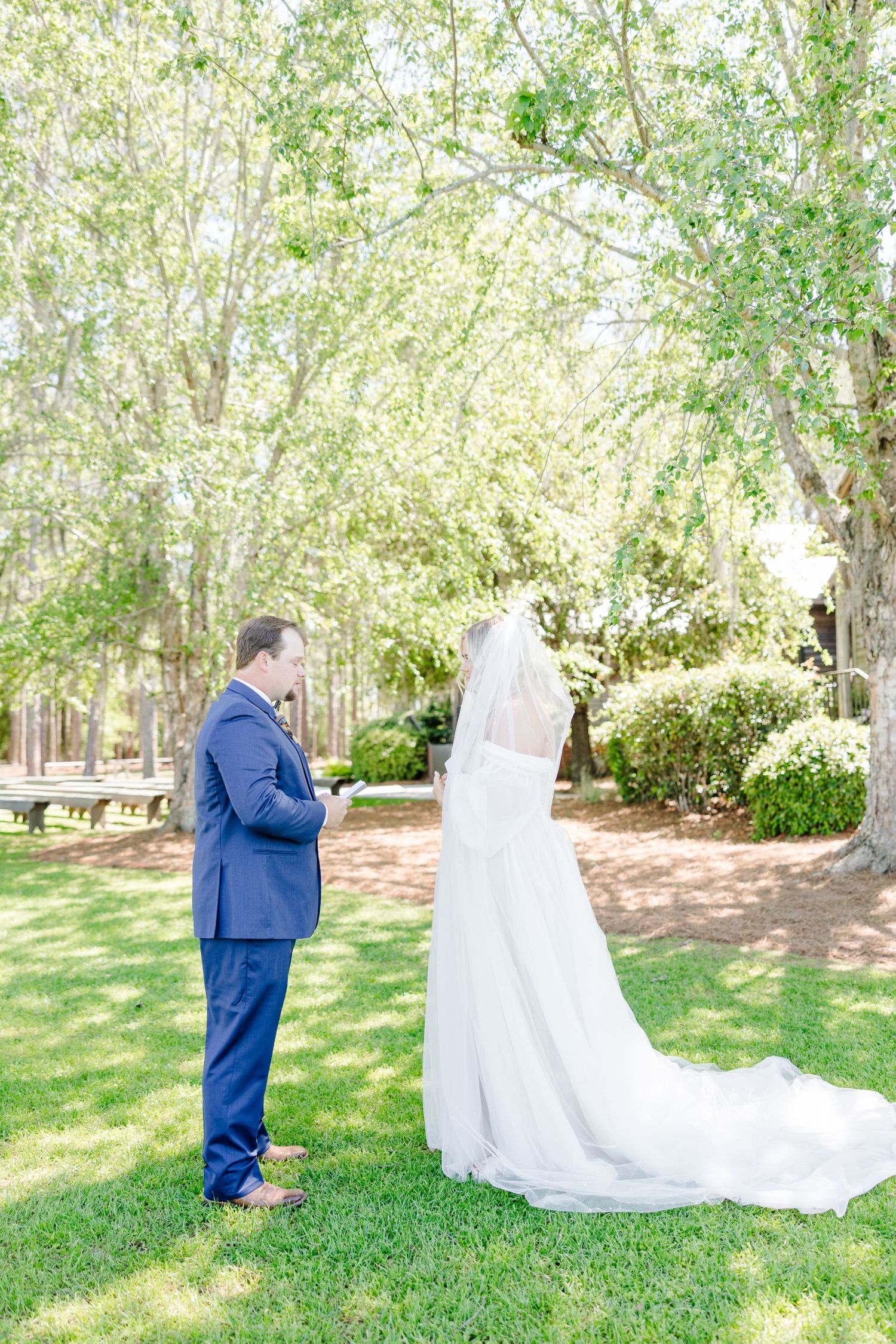 Intimate wedding ceremony moment captured under blooming trees.