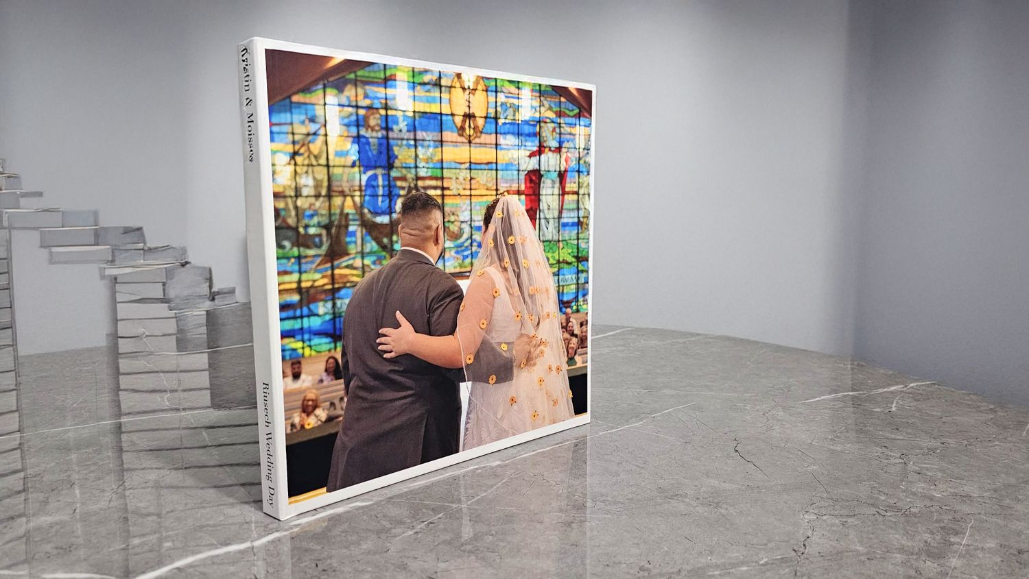 Large canvas wedding photo display showing bride and groom before colorful stained glass window.