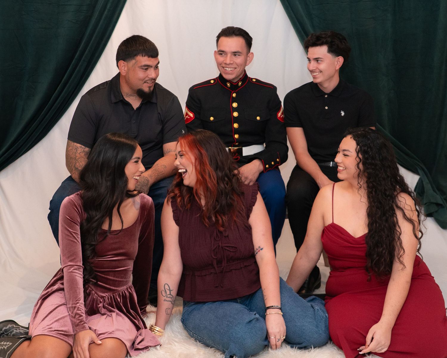 Group of six young adults posing together, one in Marine dress uniform.