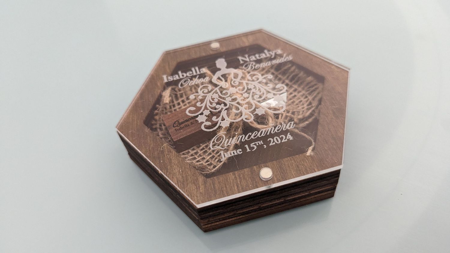 Stack of personalized hexagonal wooden coasters engraved with Quinceanera June 13th 2024.