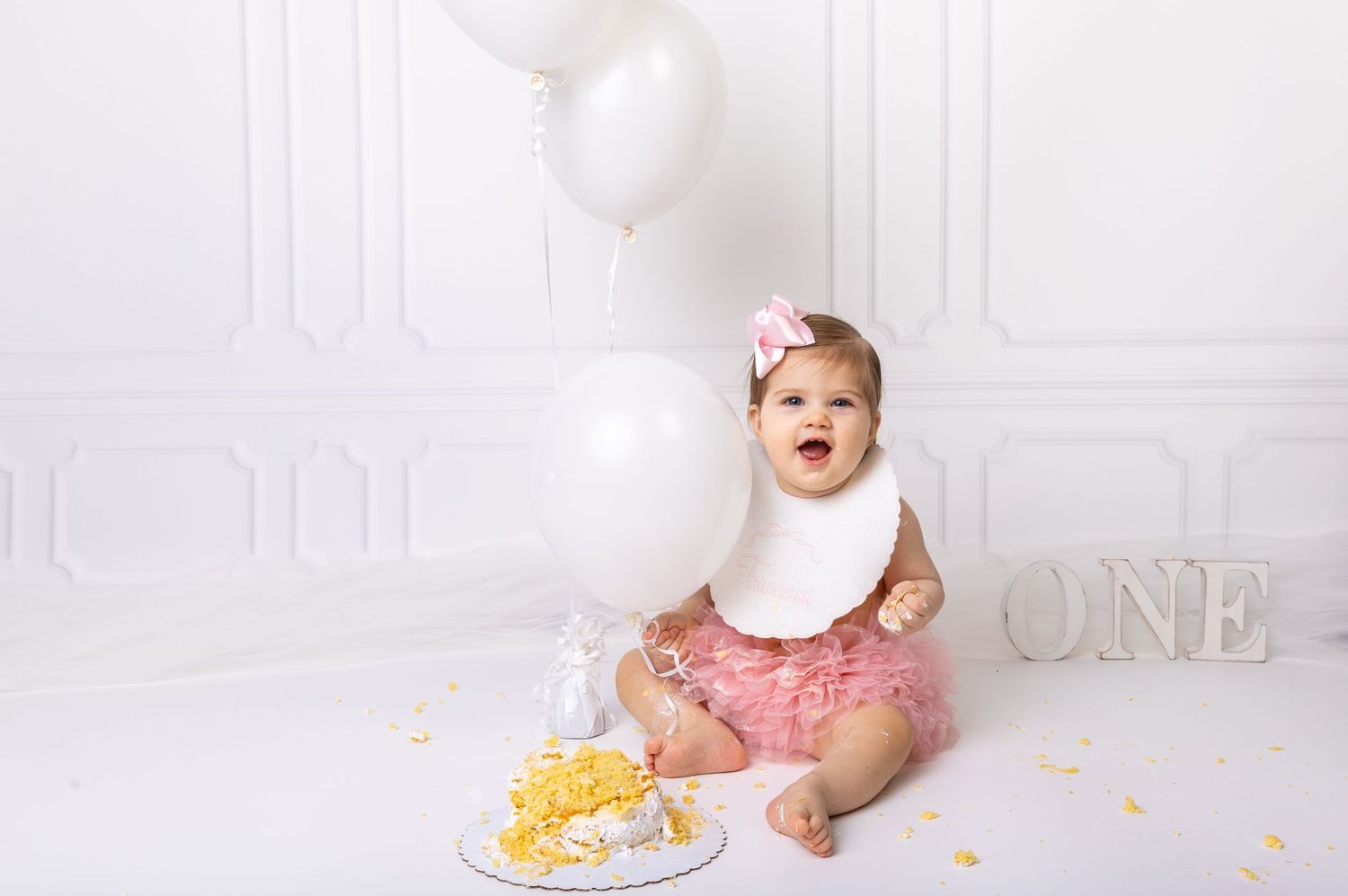 Baby during simplicity-themed cake smash in Glenview IL studio featuring a clean white backdrop, minimal decor, and a matching cake.