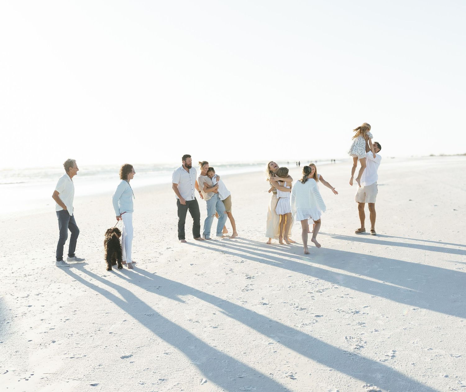 Large family session during sunset on Siesta Key Beach, showcasing beautiful natural light and a relaxed, joyful atmosphere