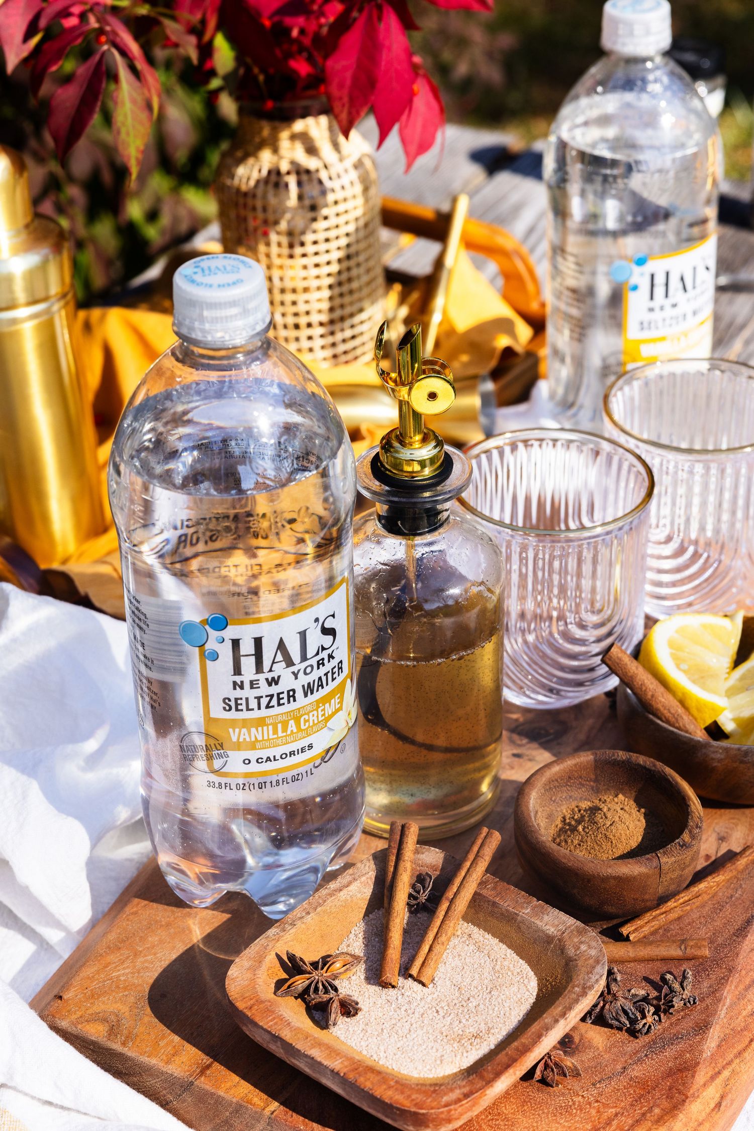 Hal's New York vanilla cream seltzer water bottle with cinnamon sticks, star anise, and spices on a wooden board.