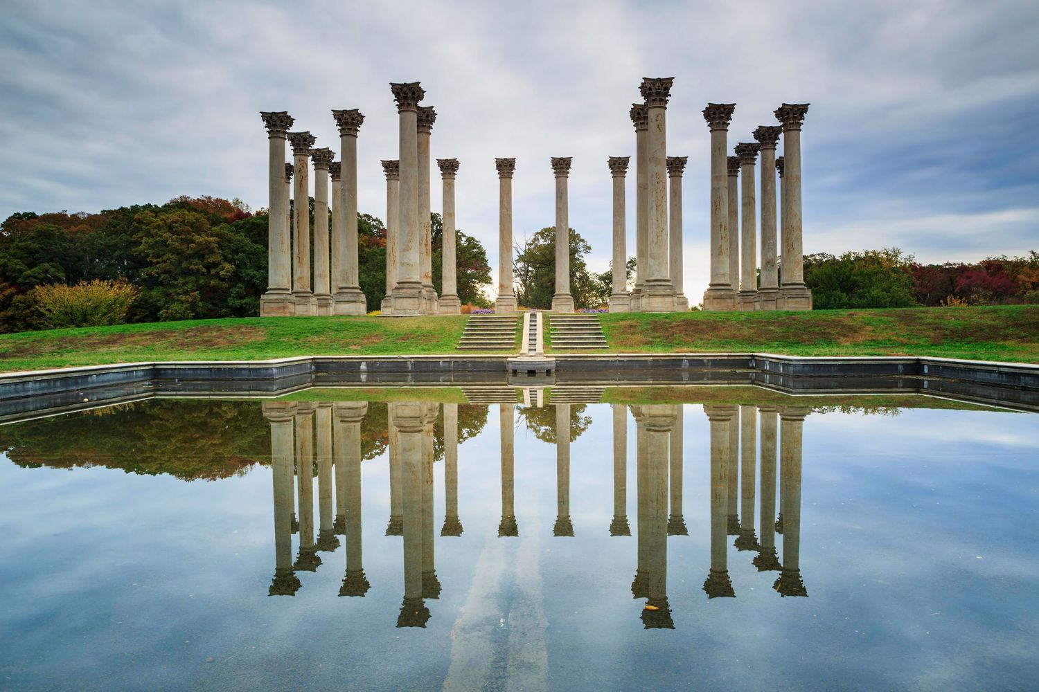 Neoclassical stone columns stand reflected in a calm pool at the National Arboretum in Washington DC.
