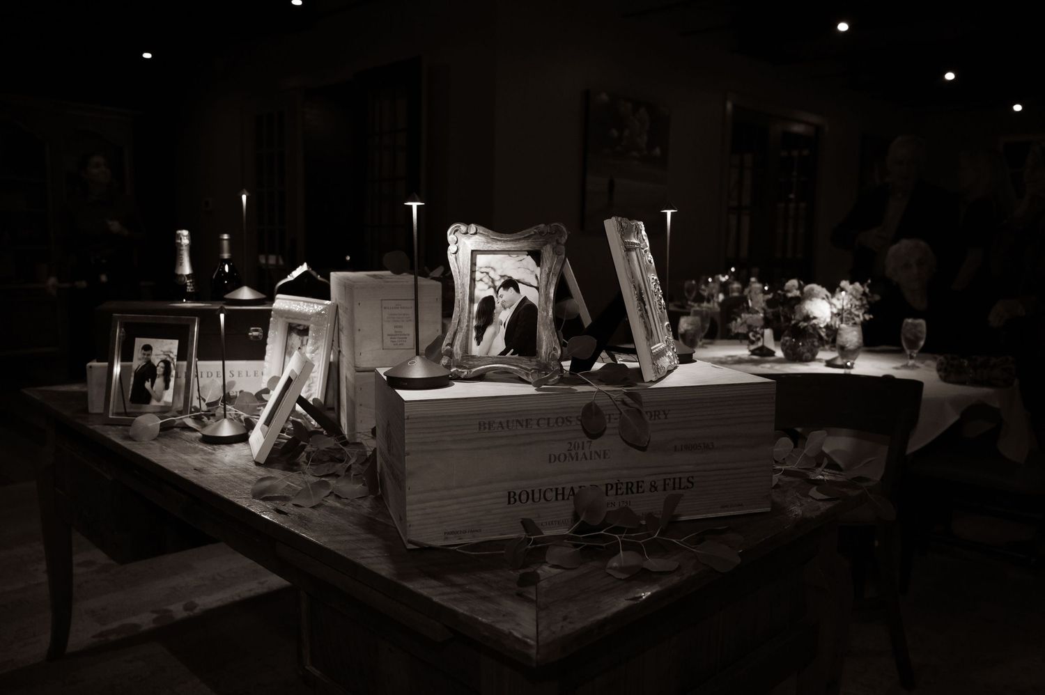 A vintage black and white still life of various frames and objects arranged on a table.