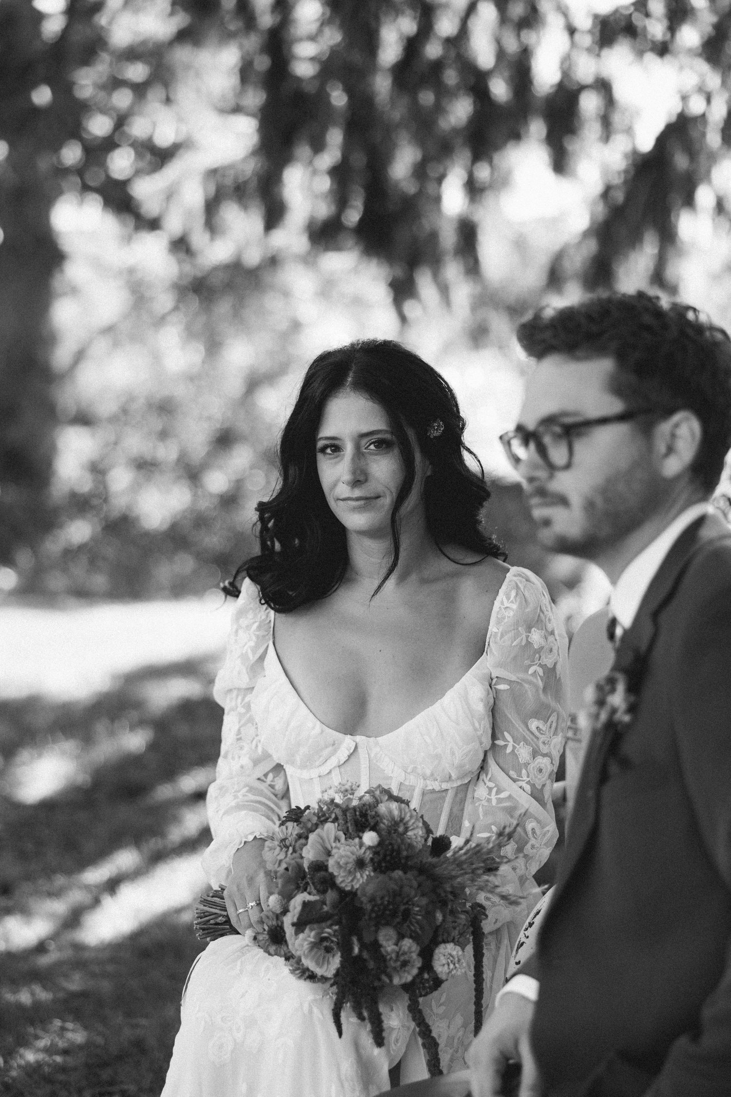 Black and white wedding photo series showing romantic moments between a couple in a garden setting.