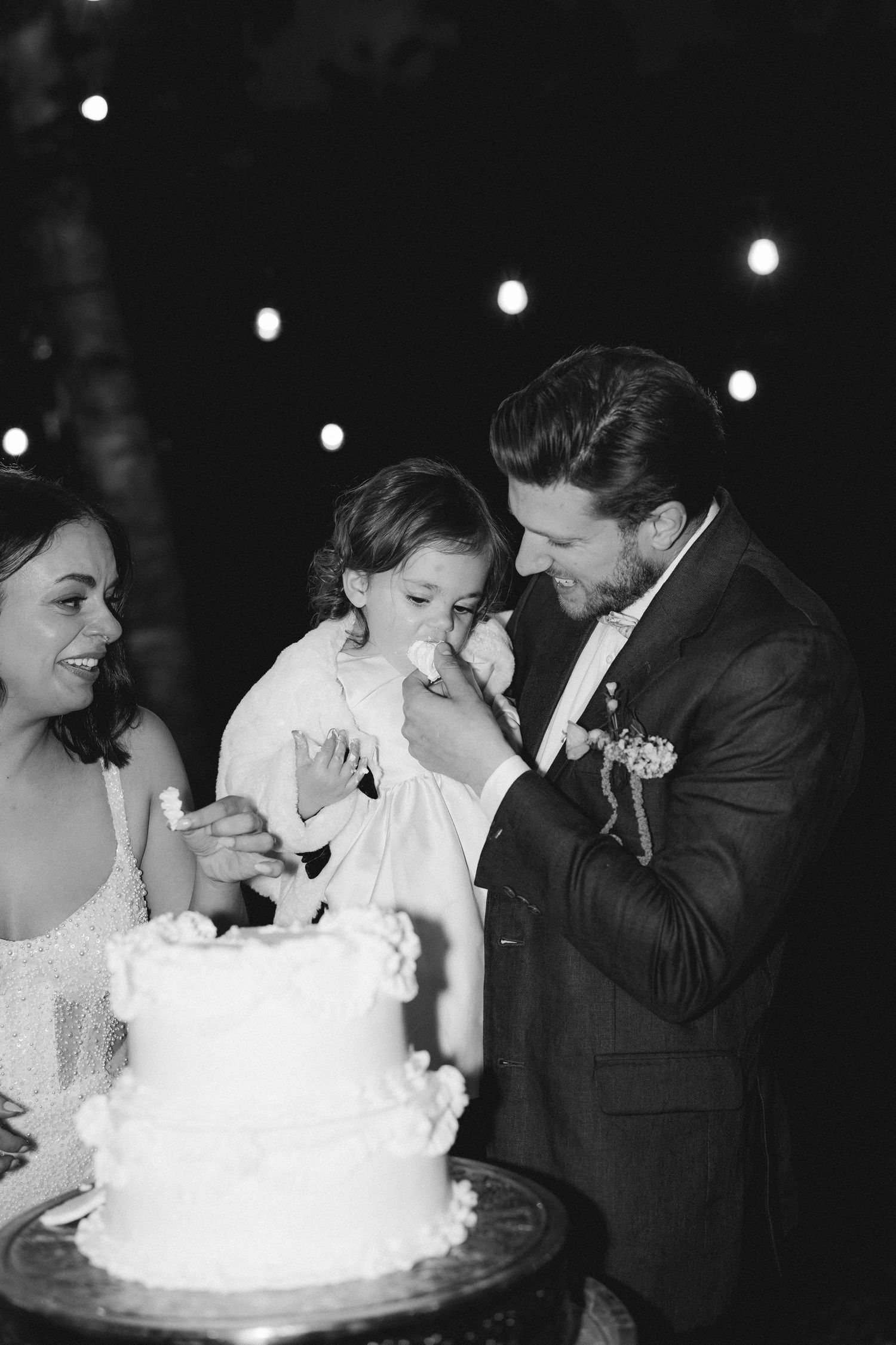 Black and white sequence of newlyweds playfully sharing their wedding cake during the reception.