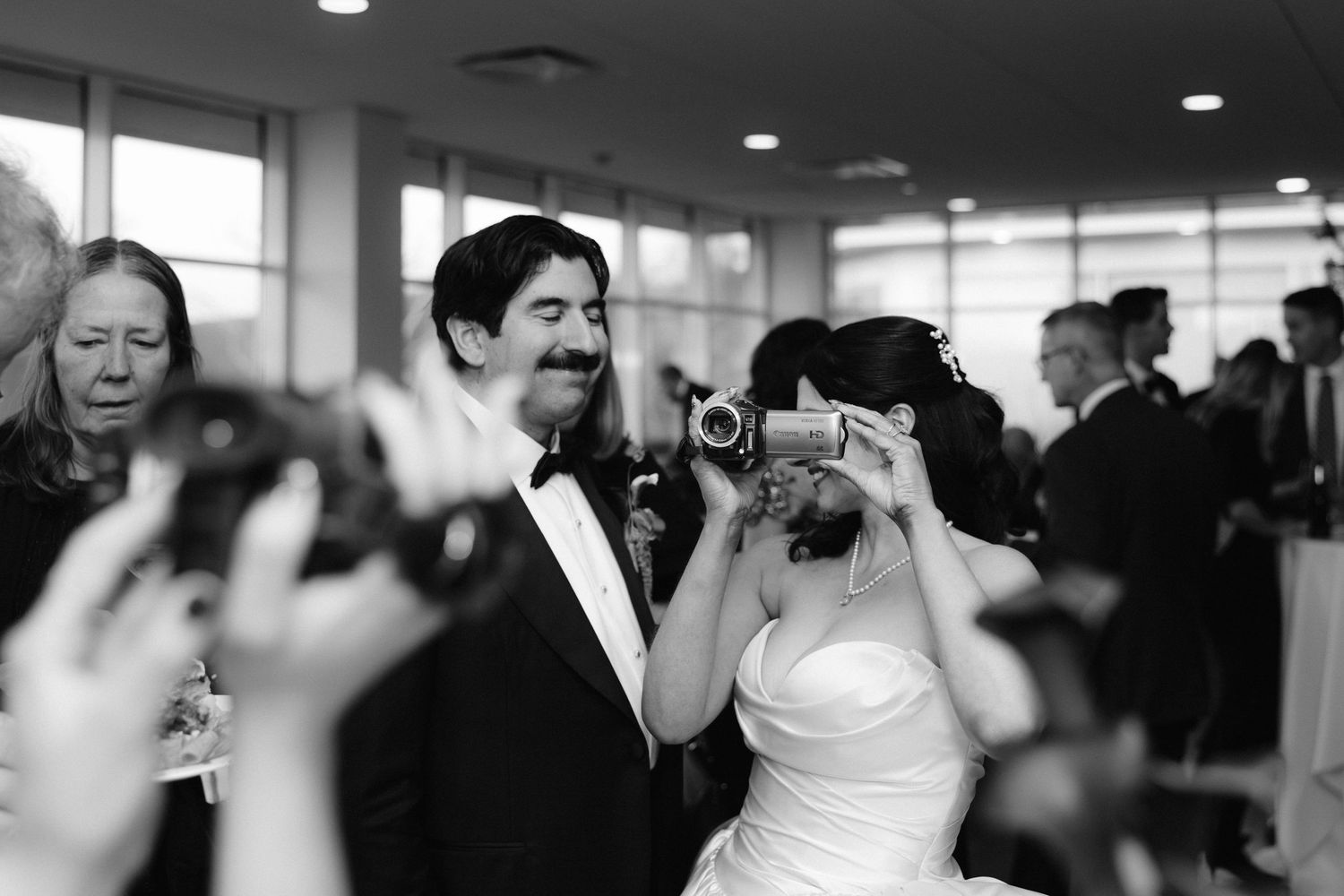Wedding guests dance and celebrate on a crowded dance floor during an indoor reception.