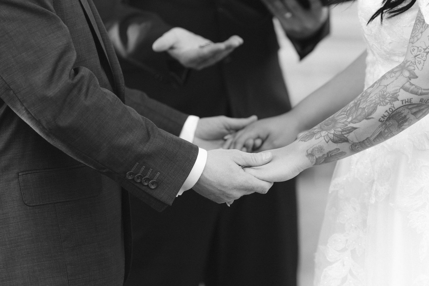 A black and white photo series showing hands exchanging rings during a wedding ceremony.