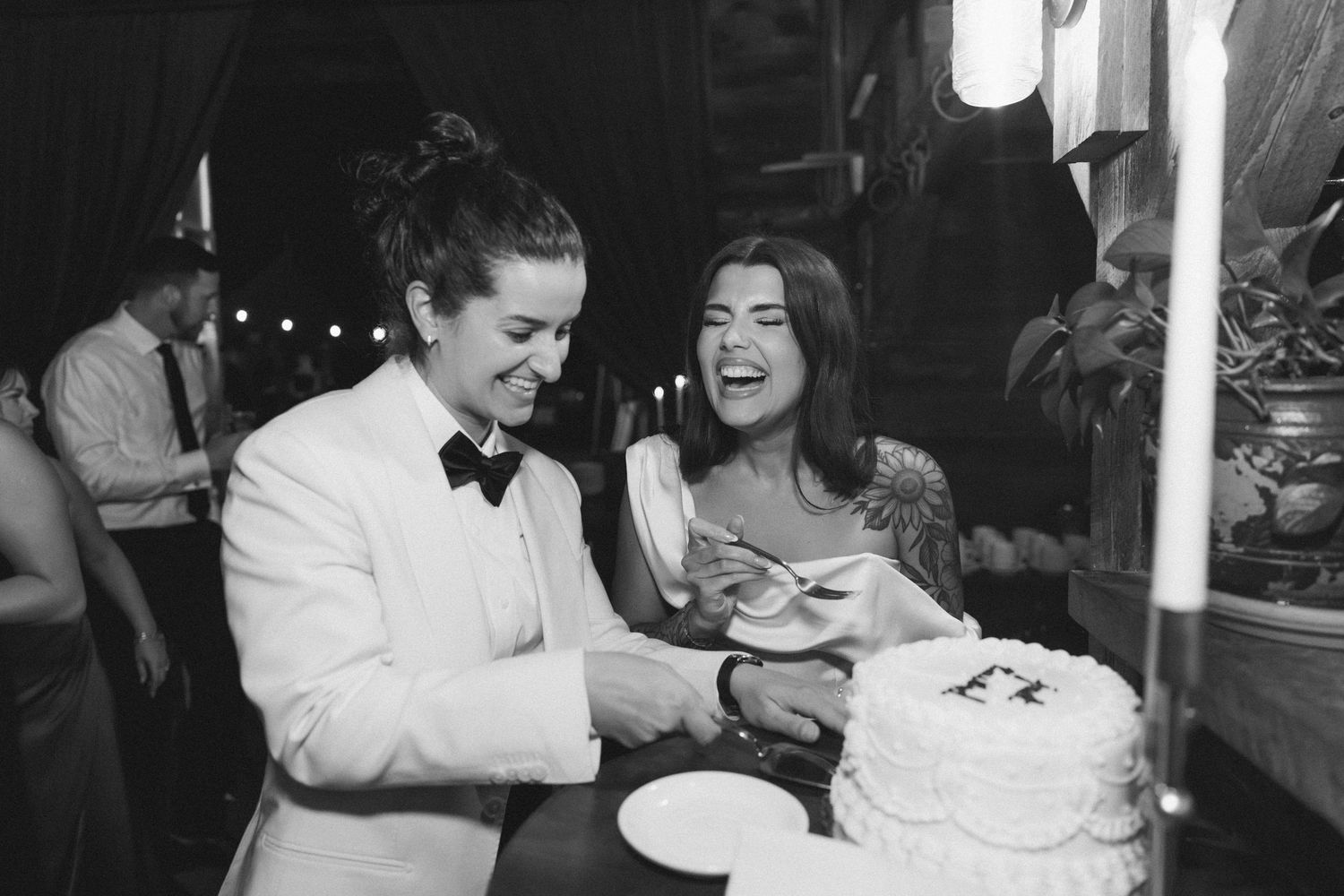 A couple shares a romantic dance together at their wedding reception in black and white photography.