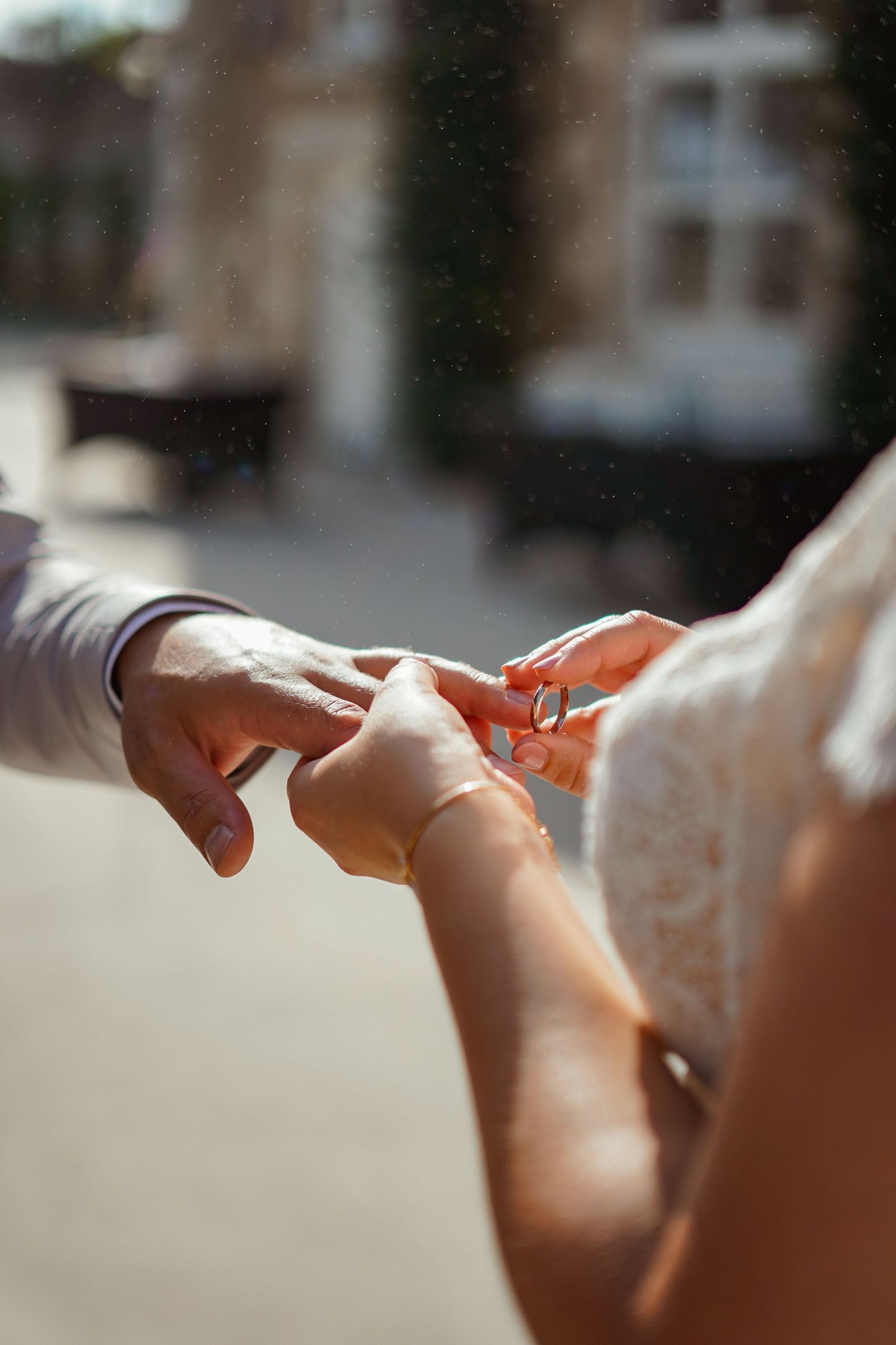 Close-up shot of hands exchanging wedding rings during an intimate ceremony moment.