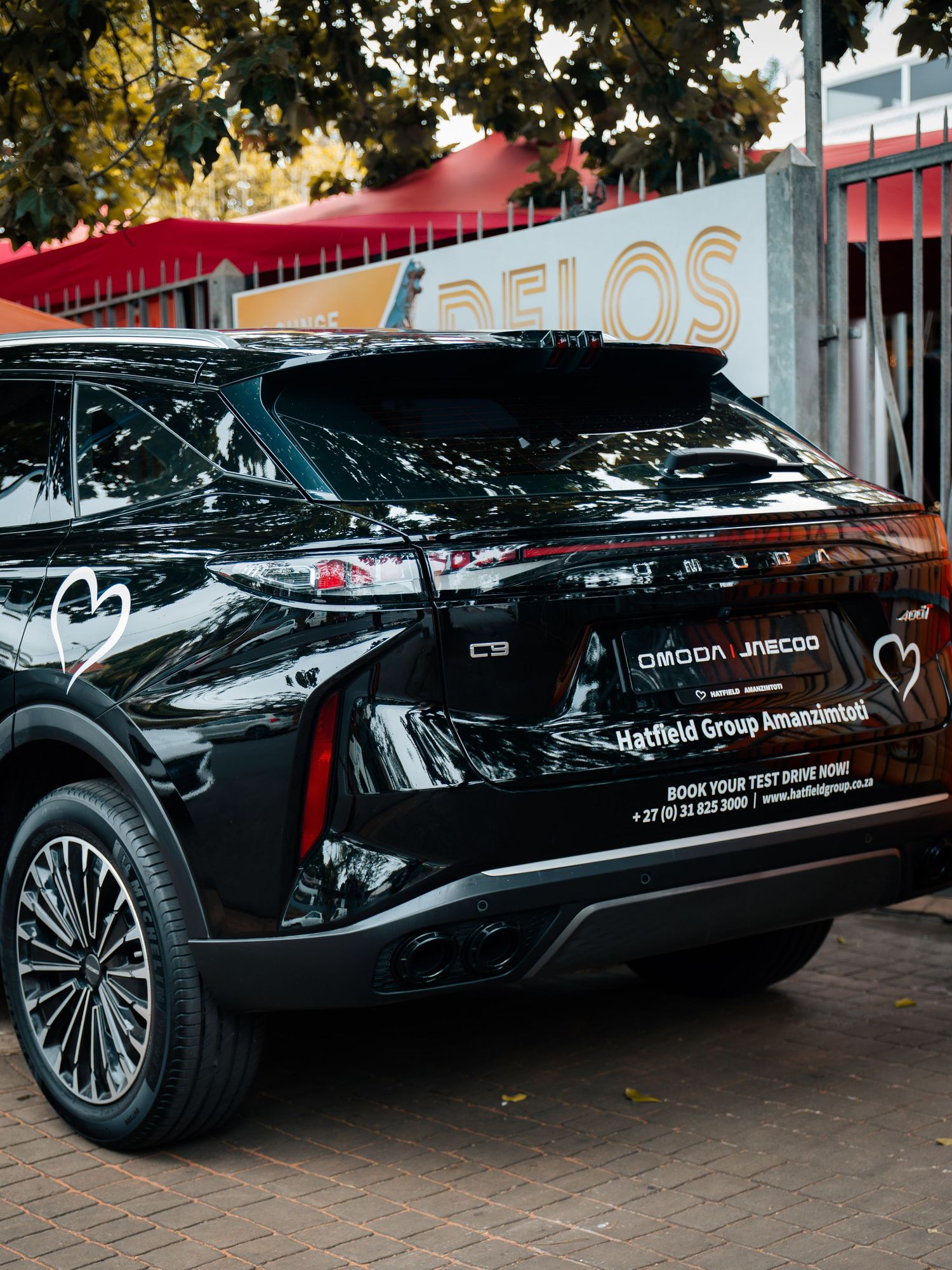 Black Omoda Jaecoo SUV parked outside Delos venue, featuring Hatfield Group Amandelbult dealership branding.