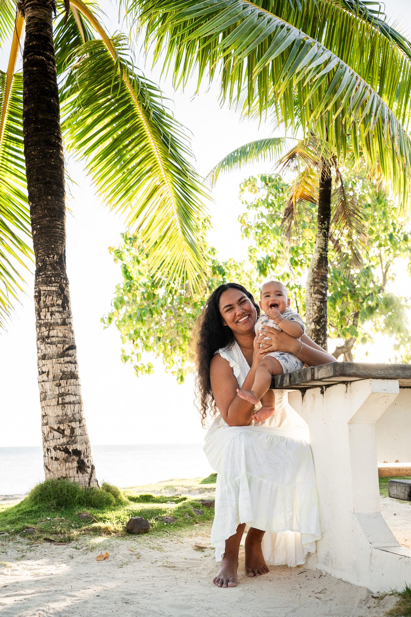 Mother holding her baby under palm trees during a Bora Bora family photoshoot