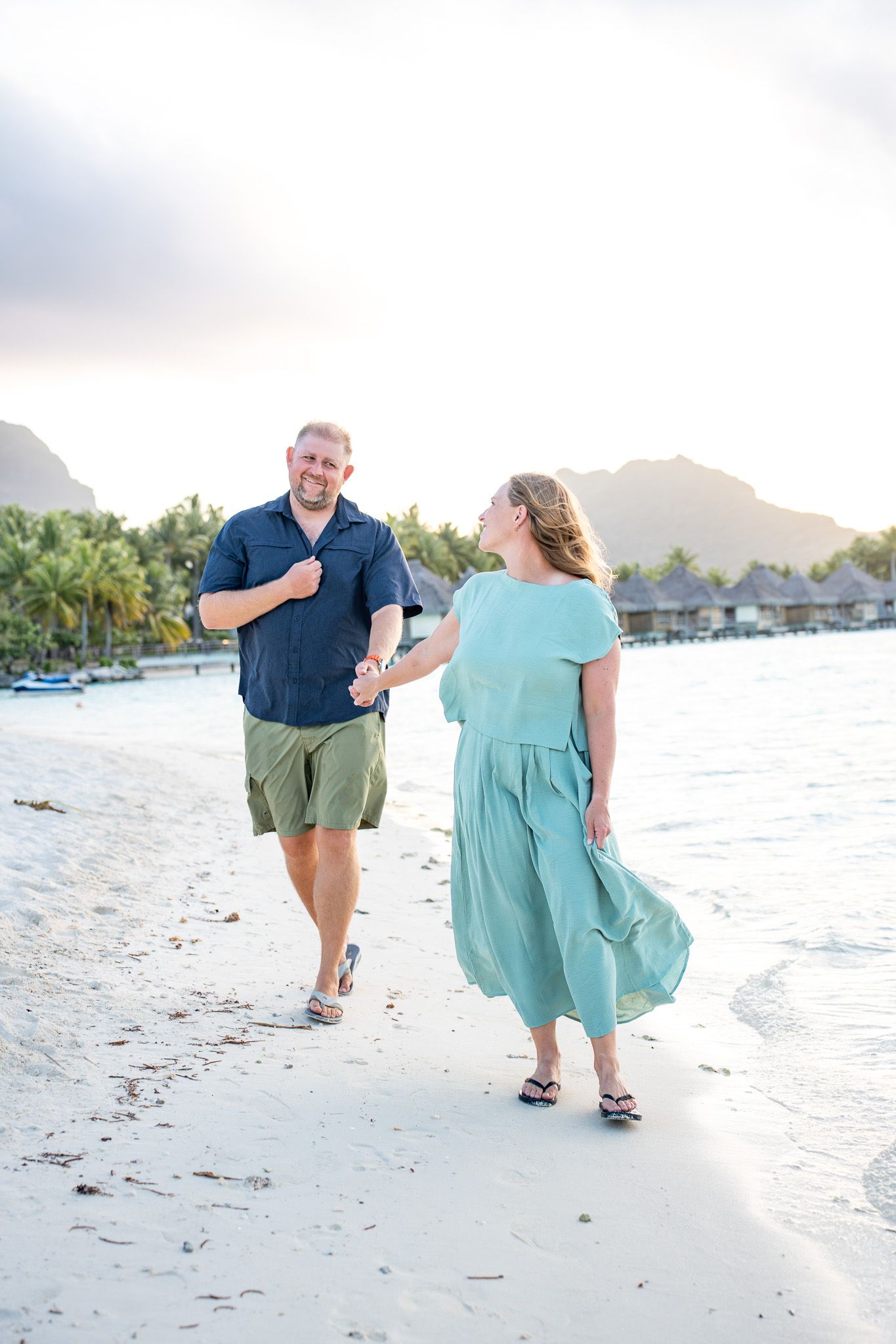 ouple walking on a white sand beach during a Bora Bora photography session