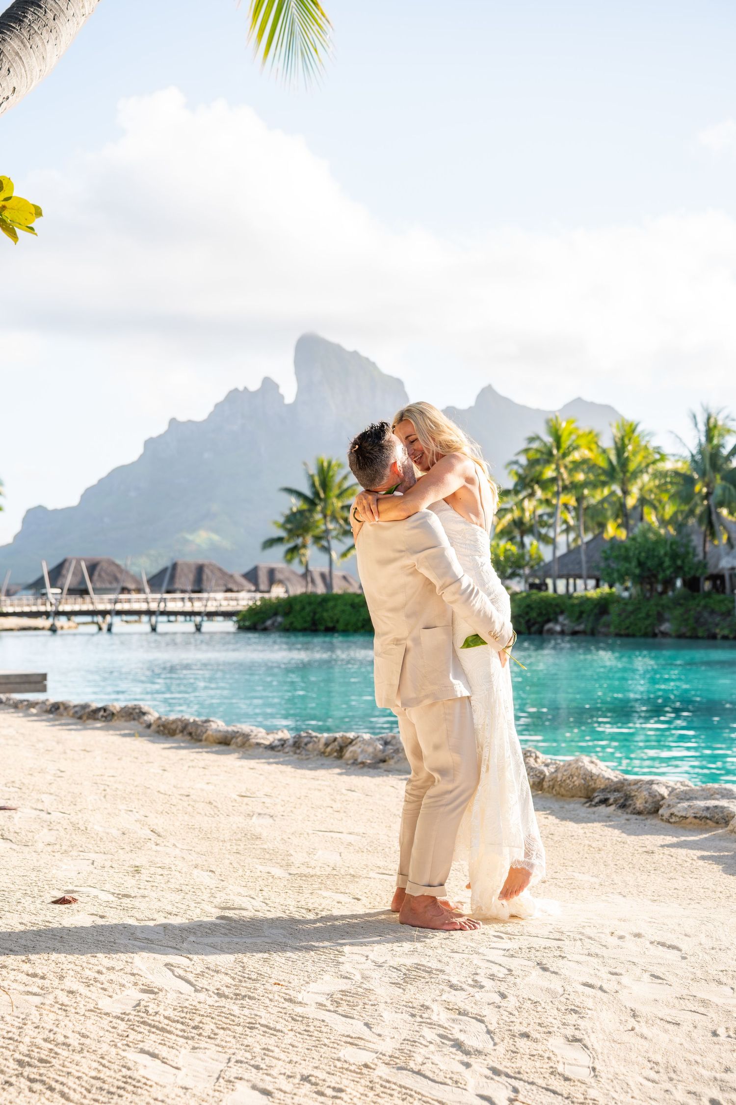 Bride and groom embracing with Mount Otemanu during their Bora Bora wedding