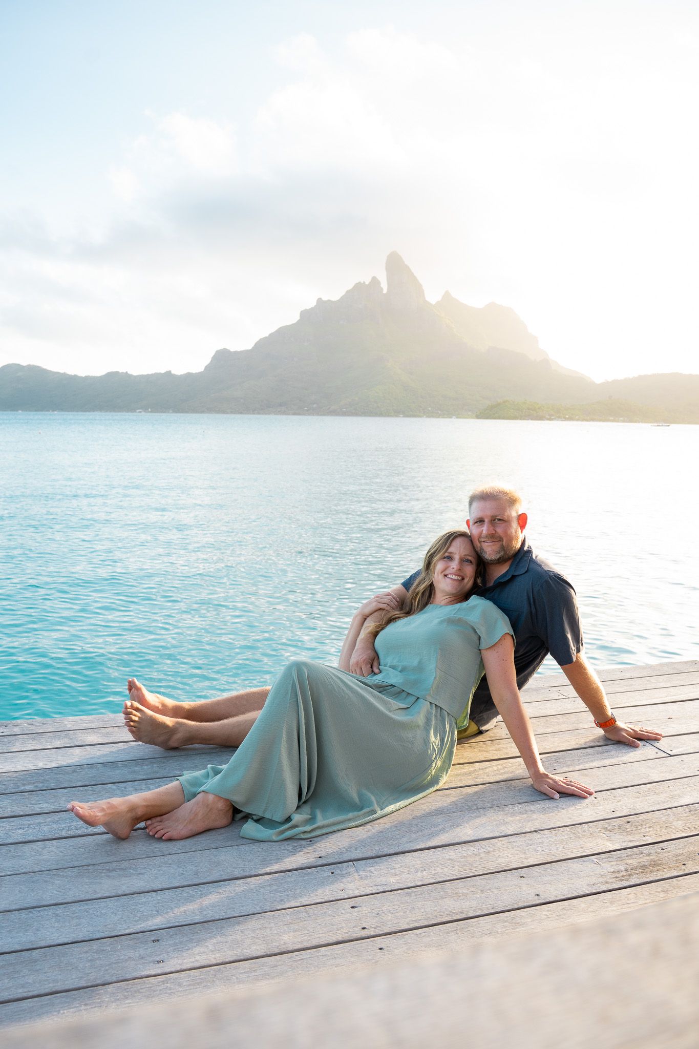 Couple relaxing by the lagoon with Mount Otemanu in Bora Bora, French Polynesia