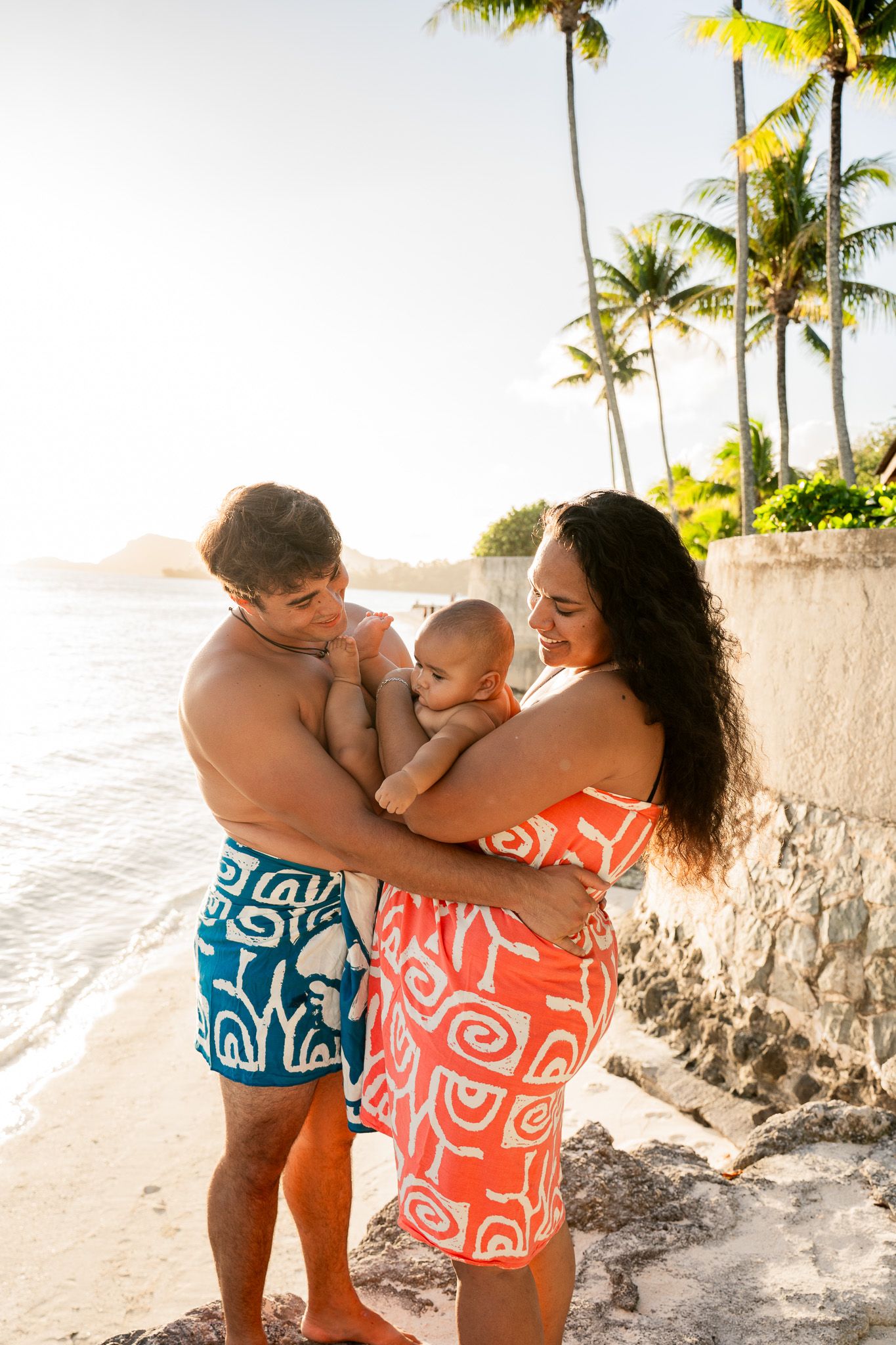 Parents holding their baby during a family beach photoshoot in Bora Bora